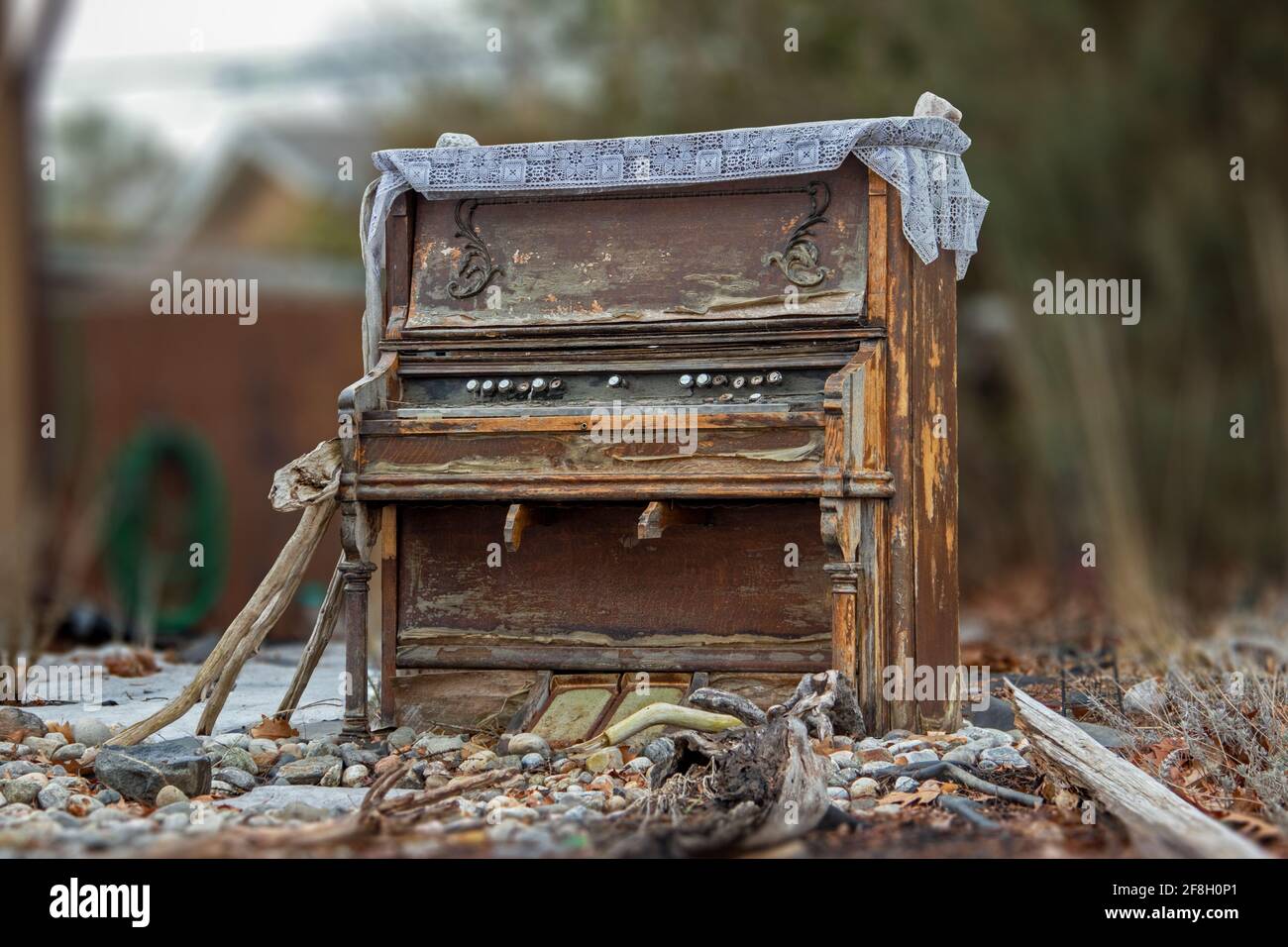 Ruiniertes Holzklavier in der Mitte einer Wohnfront Rasen Stockfoto