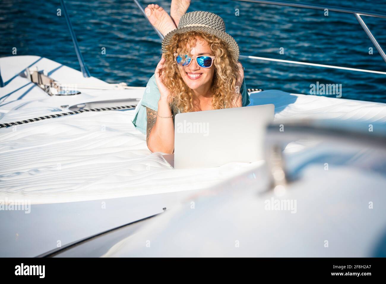 Frau lächelt auf dem Deck des Bootes in Sommerurlaub Urlaub und Laptop beobachten - Konzept der kostenlos Lifestyle modern hübsche weibliche Menschen - Compu Stockfoto Frau lächelt auf dem Deck des Bootes in Sommerurlaub Urlaub und Laptop beobachten - Konzept der kostenlos Lifestyle modern hübsche weibliche Menschen - Compu Stockfoto