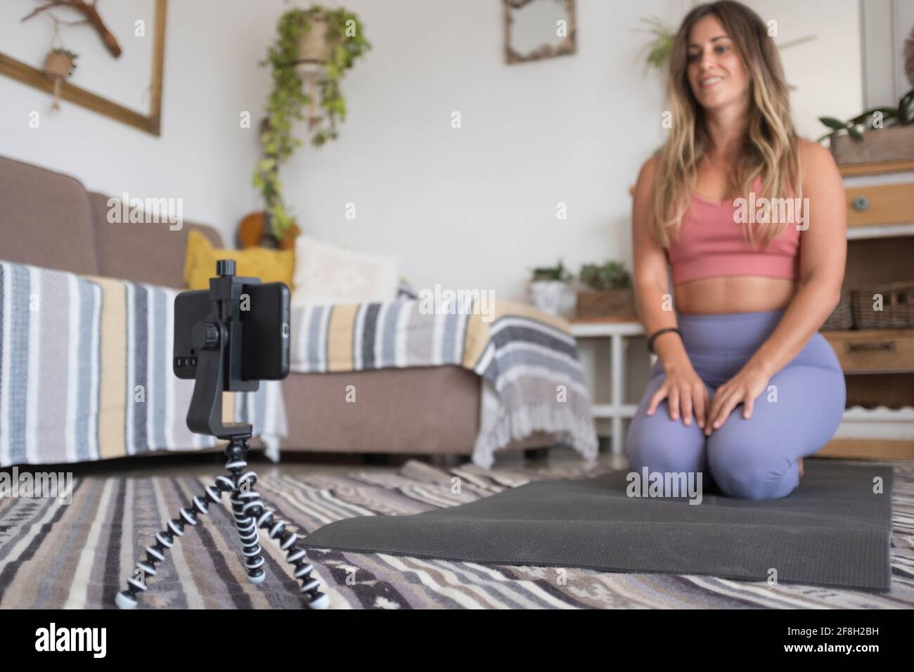 Junge Personal Trainer Heimarbeit Online-Kurs mit mobilen Telefon- und Internetverbindung – aktiver Content Creator für gesunde Lebensweise Einflussnehmer – Mo Stockfoto