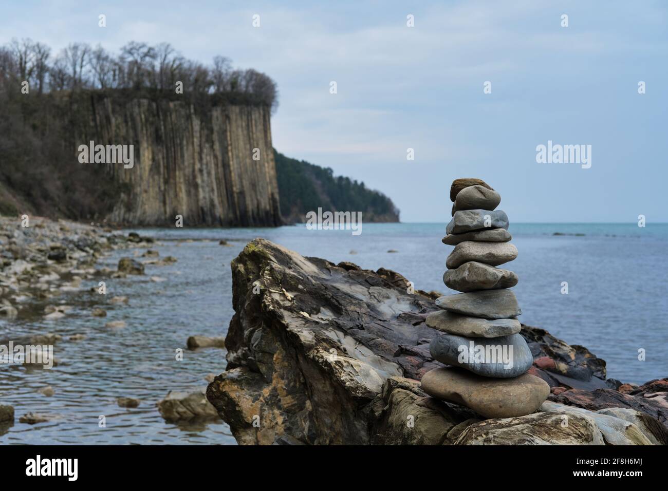 Schöne Seascape Bildschirmschoner für Desktop. In einer Pyramide gestapelte Steine übereinander. Balanceturm aus Seesteinen mit Blick auf einen Hig Stockfoto