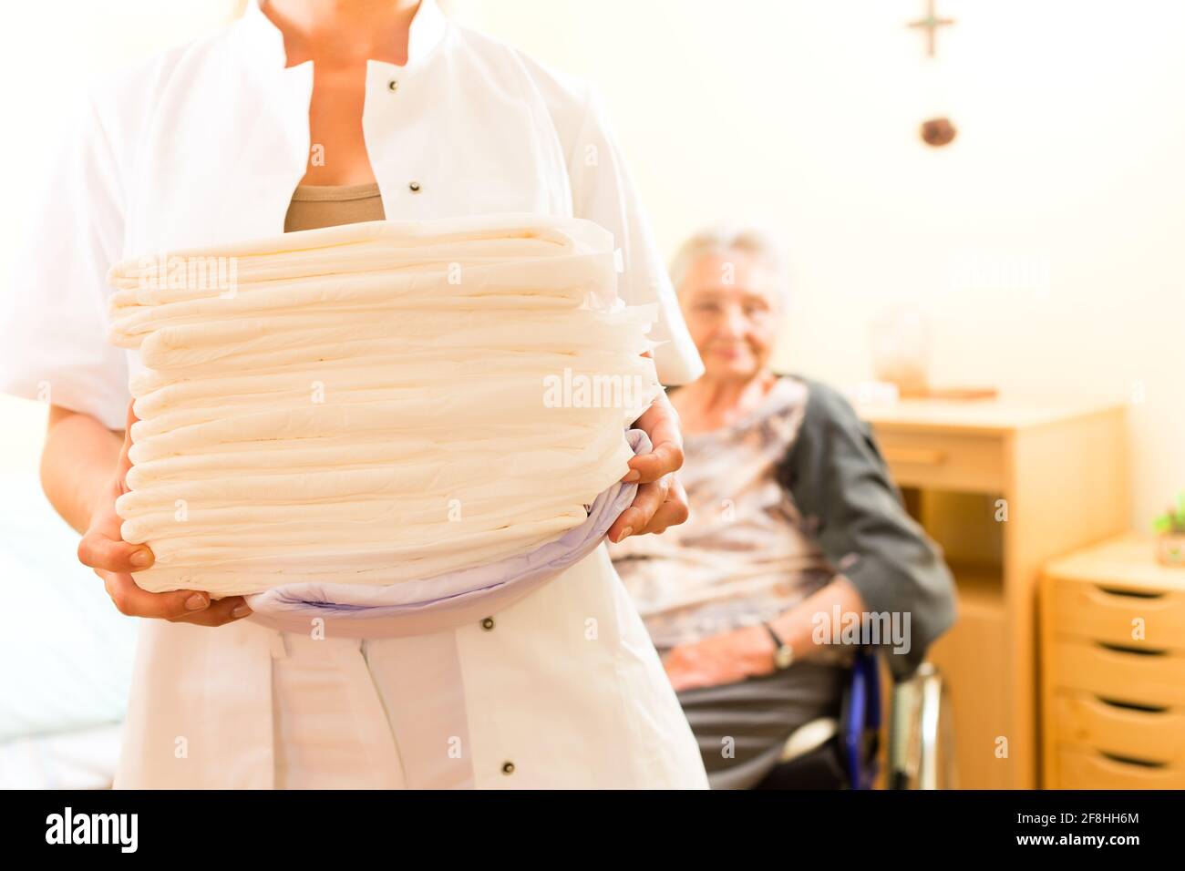 Junge Krankenschwester und weiblichen Senioren im Altersheim, die Handtücher gewechselt Stockfoto