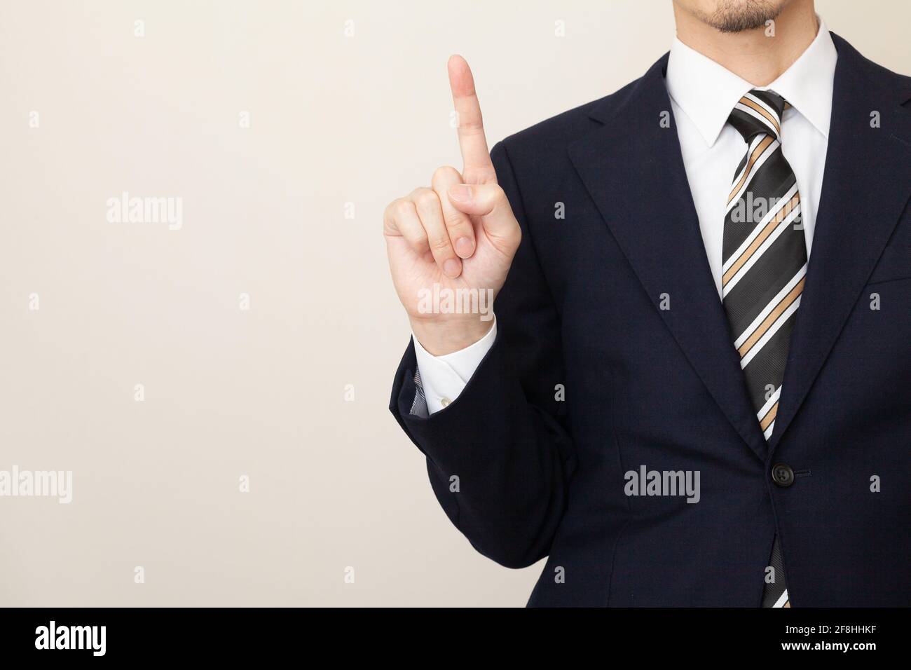 Ein Mann in einem Anzug, der die Punkte mit einem erklärt Geste des Anhebens des Zeigefingers Stockfoto
