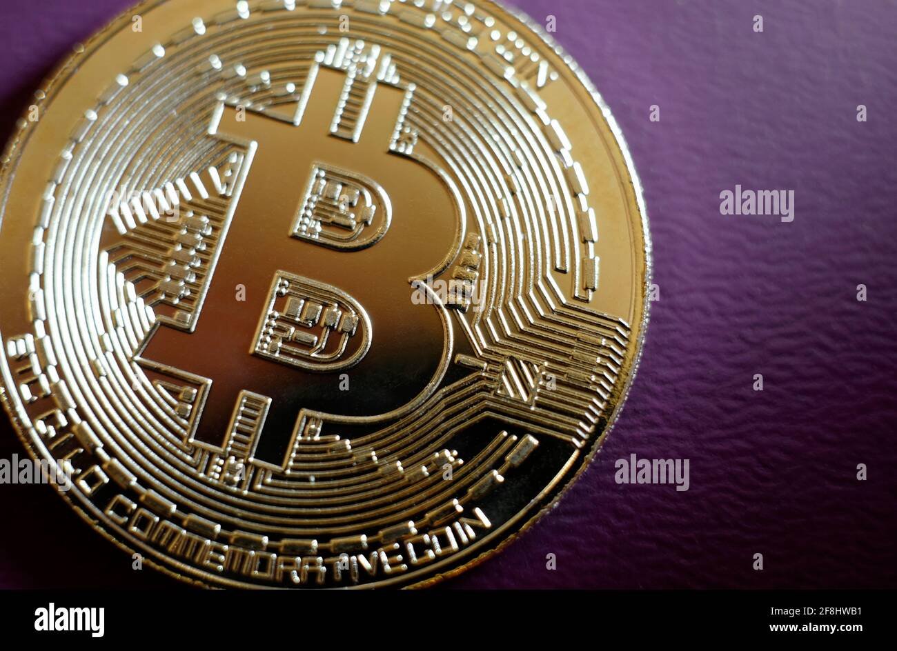 Vergoldete Bitcoin-Münze auf violettem Hintergrund Stockfoto