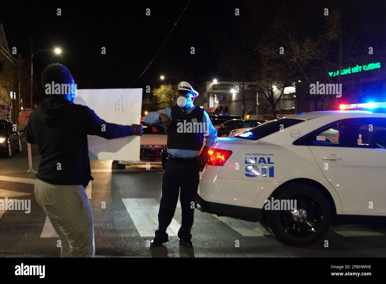 Philadelphia, USA. April 2021. Ein Demonstrator hält ein Schild vor einem Polizeibeamten in Philadelphia während eines Protestes der Justiz für Daunte Wright in Philadelphia, USA. Daunte Wright war ein 20-jähriger schwarzer Mann, der am 11. April von einem Polizisten im Brooklyn Center, Minnesota, angeschossen und getötet wurde. Kredit: Chase Sutton/Alamy Live Nachrichten Stockfoto