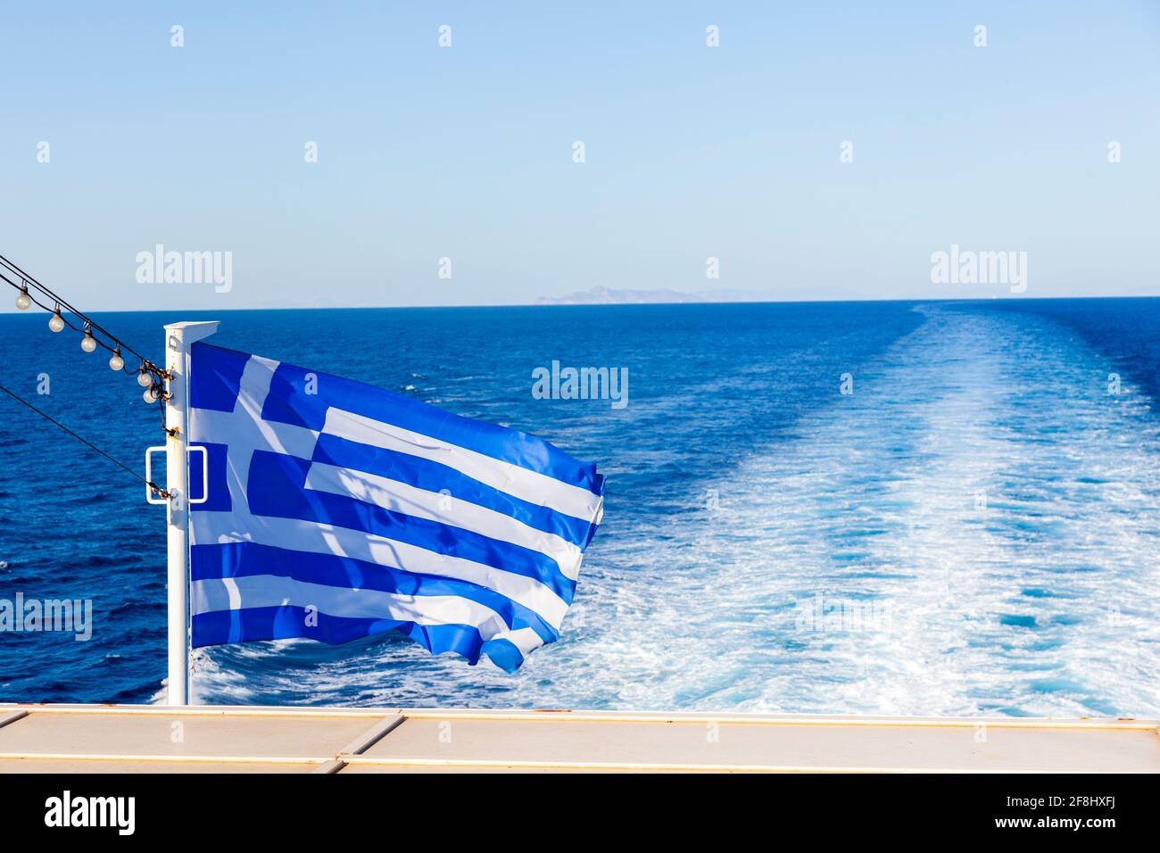 Griechische wehende Flagge auf einem Schiff während der Ägäis Überfahrt zu den Inseln der Kykladen. Stockfoto