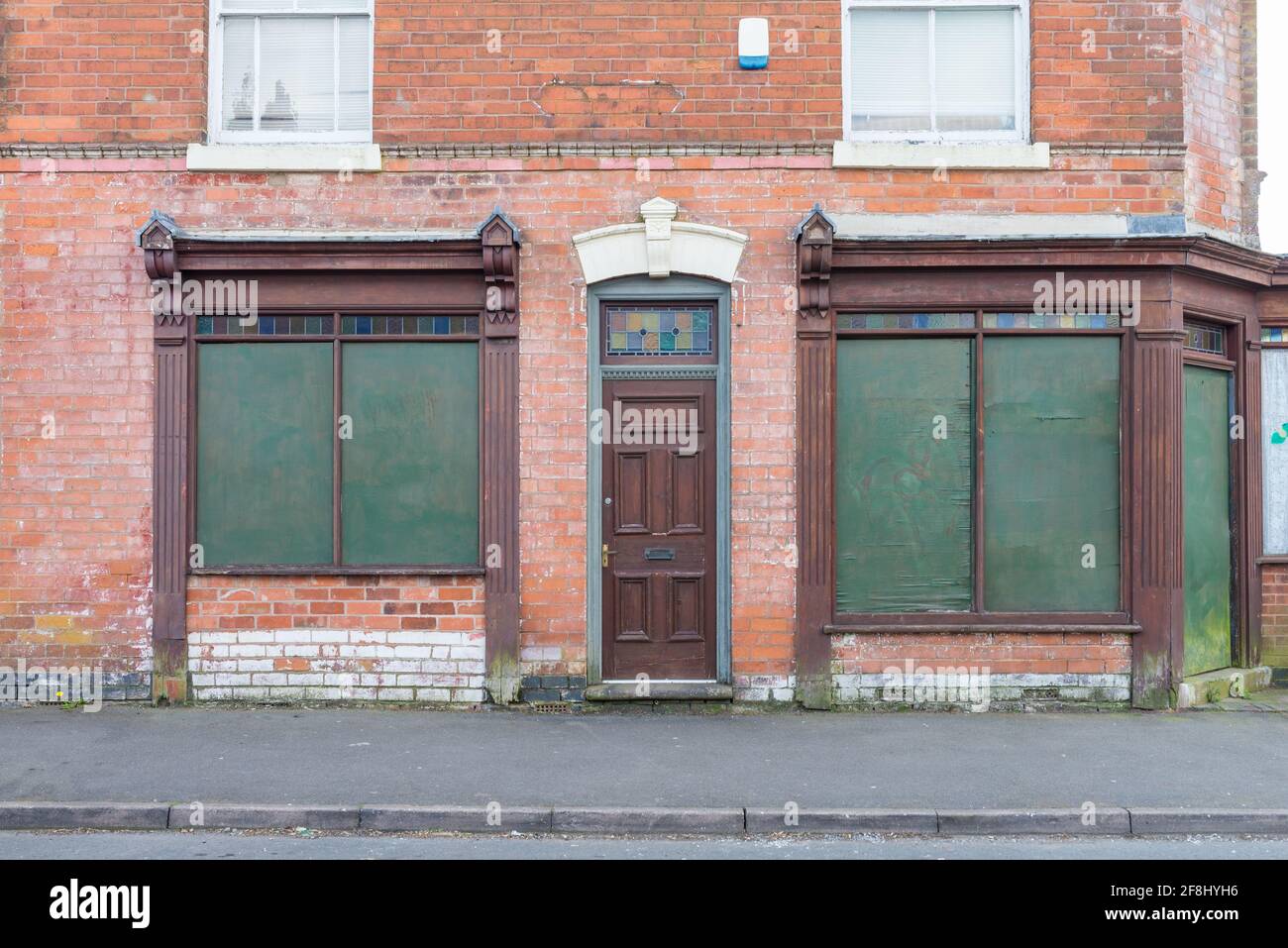 Blockierte Fenster eines ehemaligen viktorianischen Eck-Ladens mit kunstvollen Holzrahmen in Kings Heath, Birmingham, Großbritannien Stockfoto