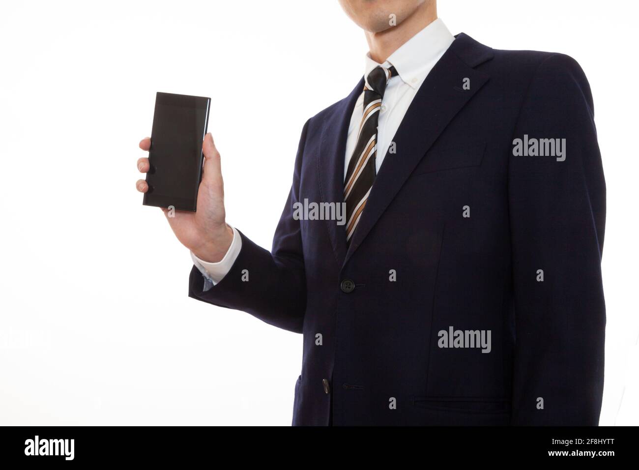 Ein Mann in einem Anzug, der ein Smartphone in seinem Gerät betreibt Rechte Hand Stockfoto