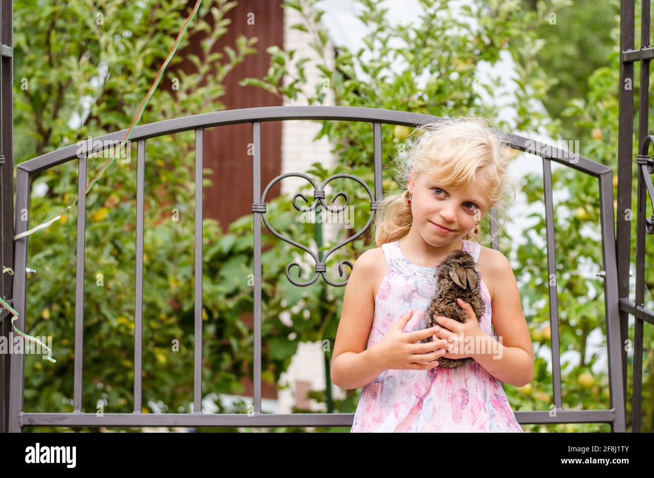 Entzückende kleine blonde Mädchen hält einen Hasen Kaninchen Haustier Stockfoto