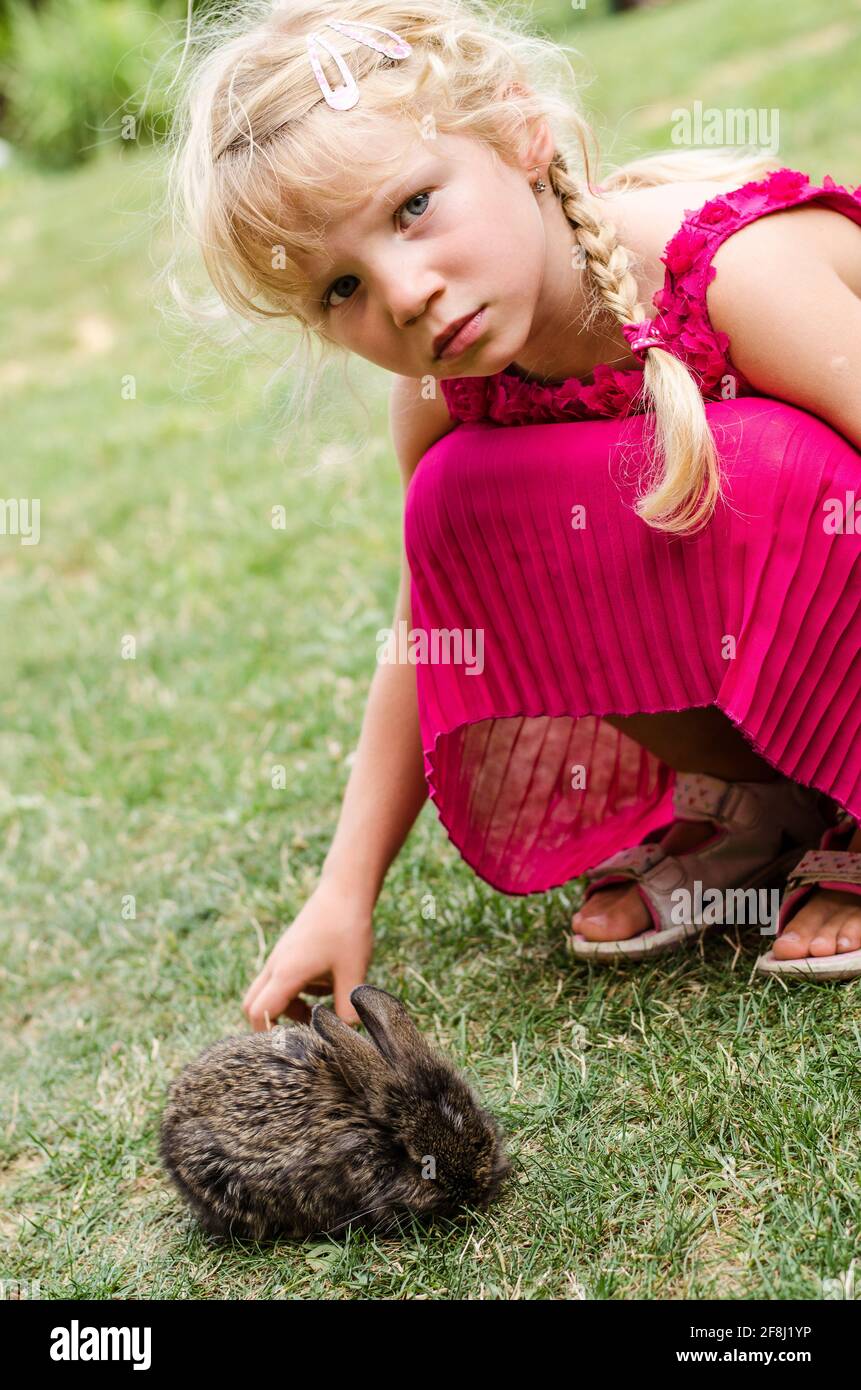 Liebenswert kleine blonde Mädchen mit Hase Kaninchen Haustier Stockfoto