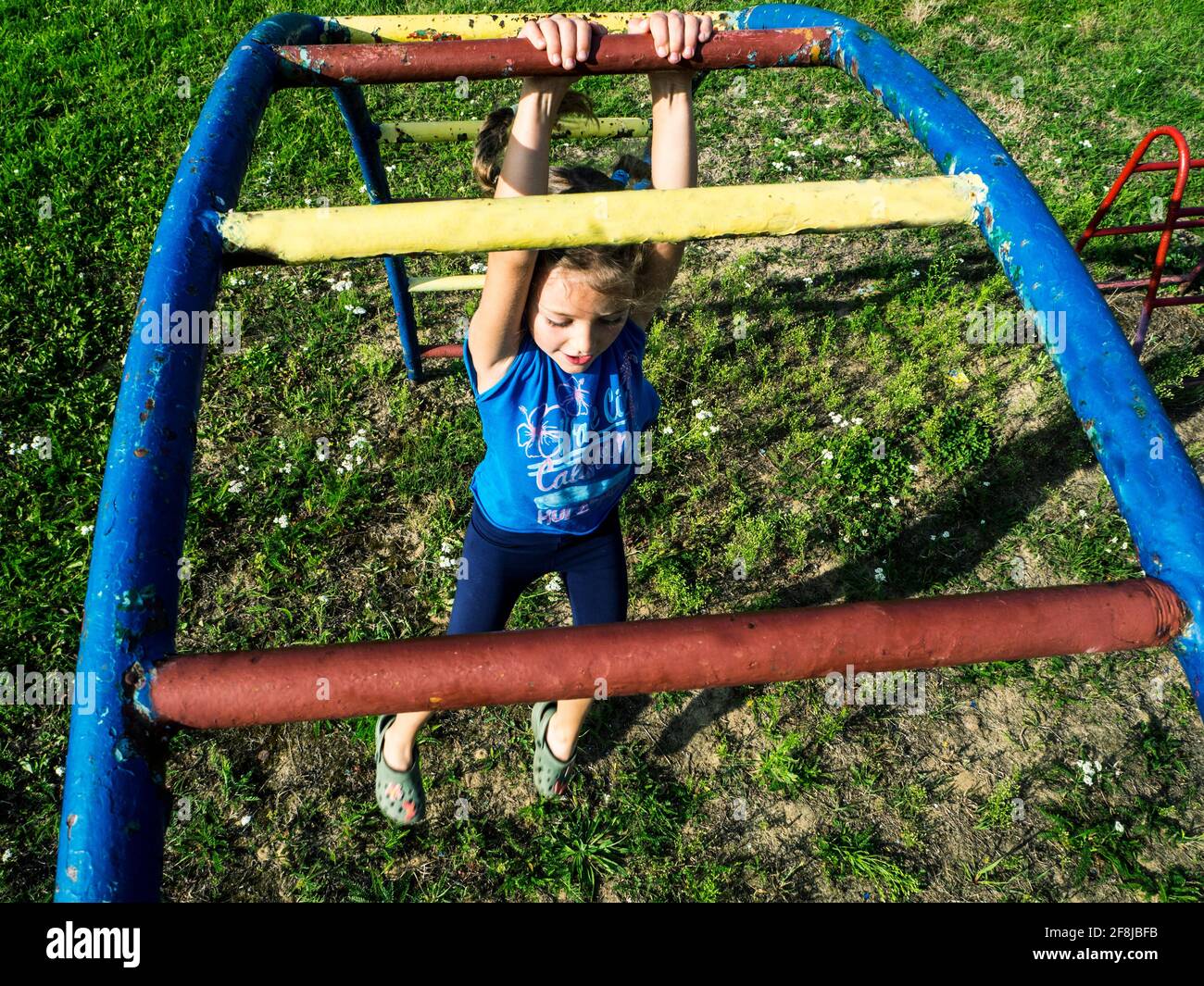 Ansicht eines Mädchens, das auf einem Klettergerüst auf einem Spielplatz in Polen hängt Stockfoto