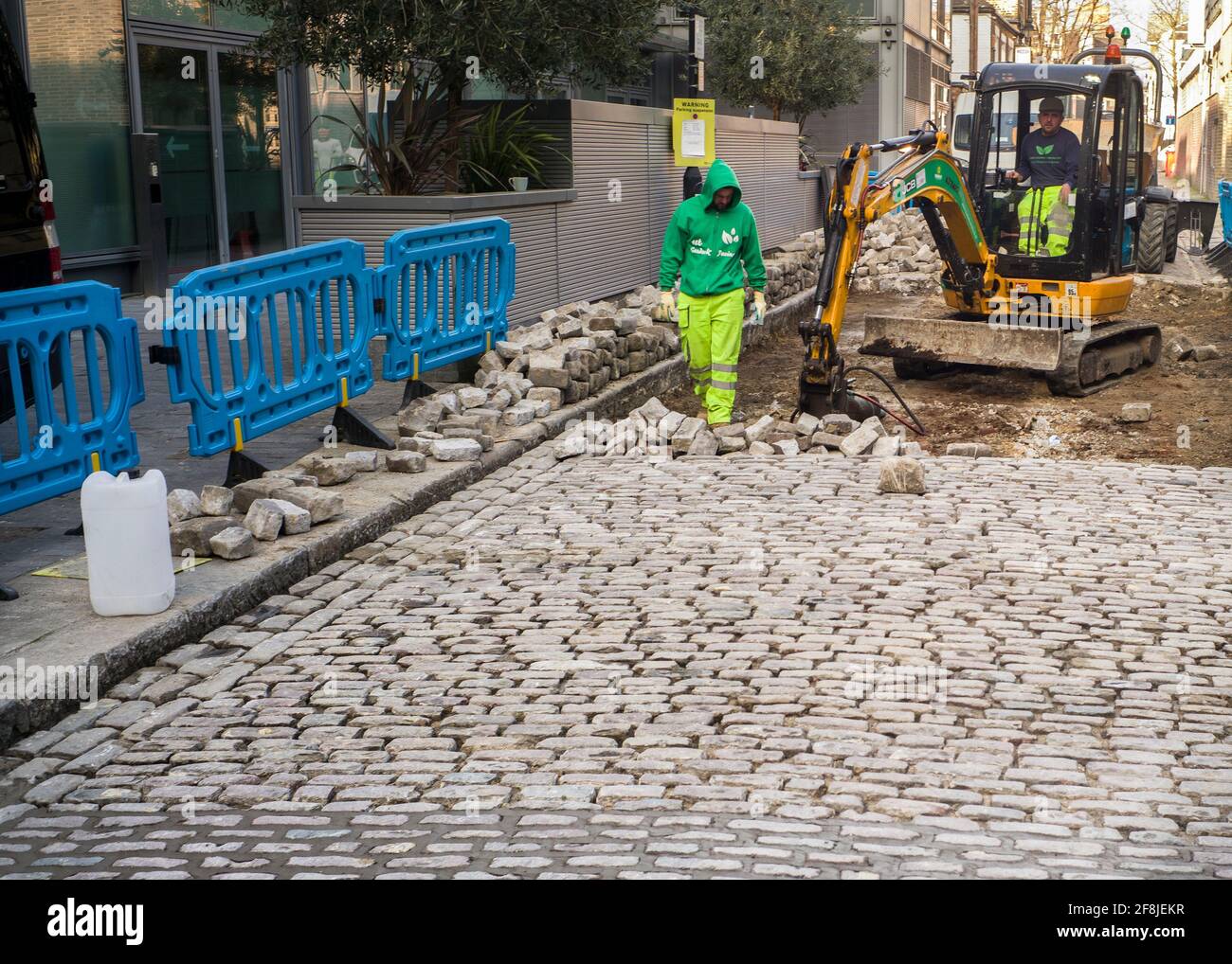 Arbeiter, die eine gepflasterter Straße schaffen Stockfoto