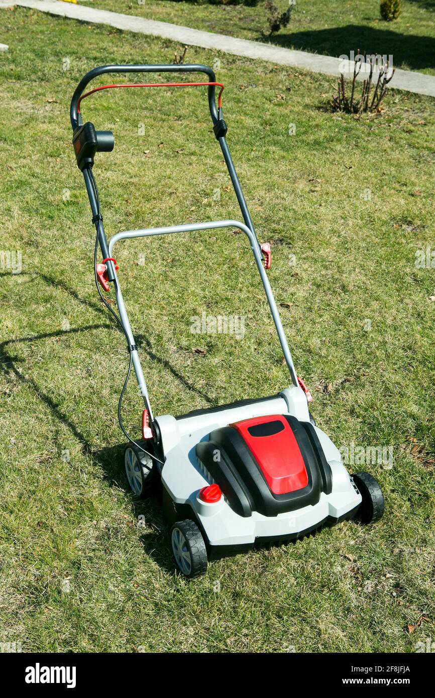 Luftbelüfter im Gras stehend. Belüftung mit einem Vertikutierer. Mit einem Scarifier im Garten zur Verbesserung der Rasenqualität im Frühjahr. Stockfoto