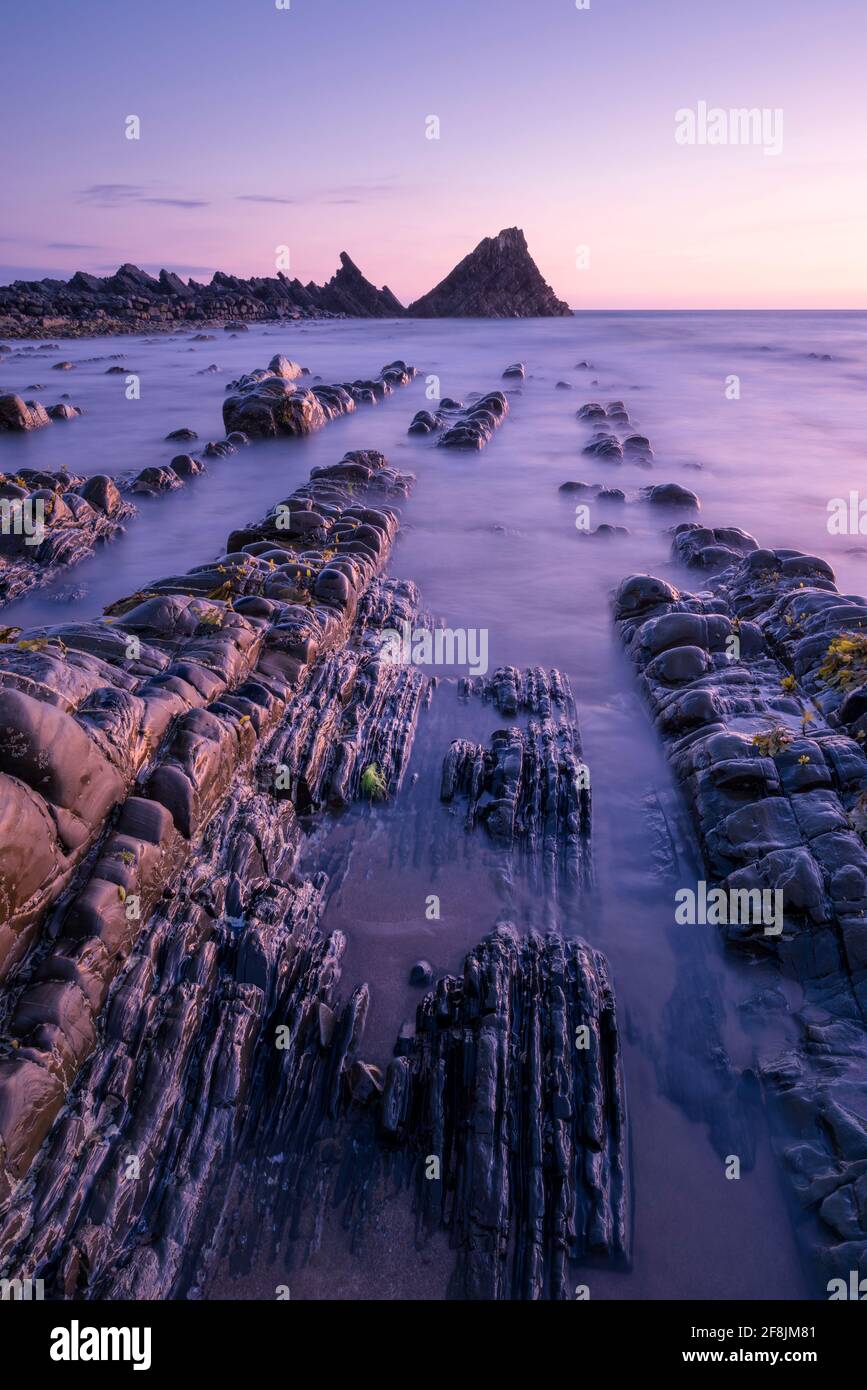Der exponierte Strand bei Ebbe am Hartland Quay in der North Devon Coast National Landscape in der Abenddämmerung, England. Stockfoto