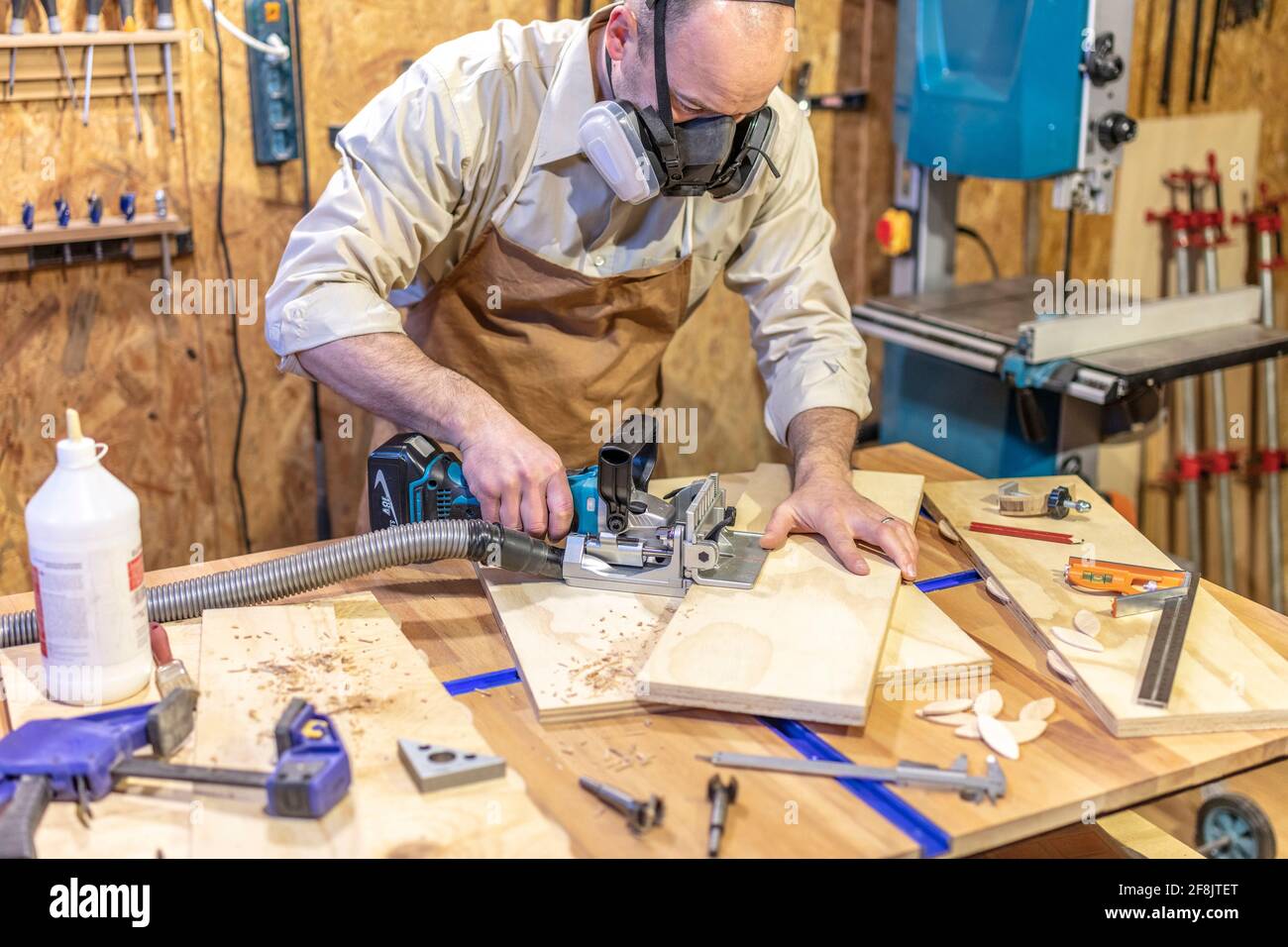Zimmermann bei der Arbeit in seiner Werkstatt mit einem Keksjointer Stockfoto