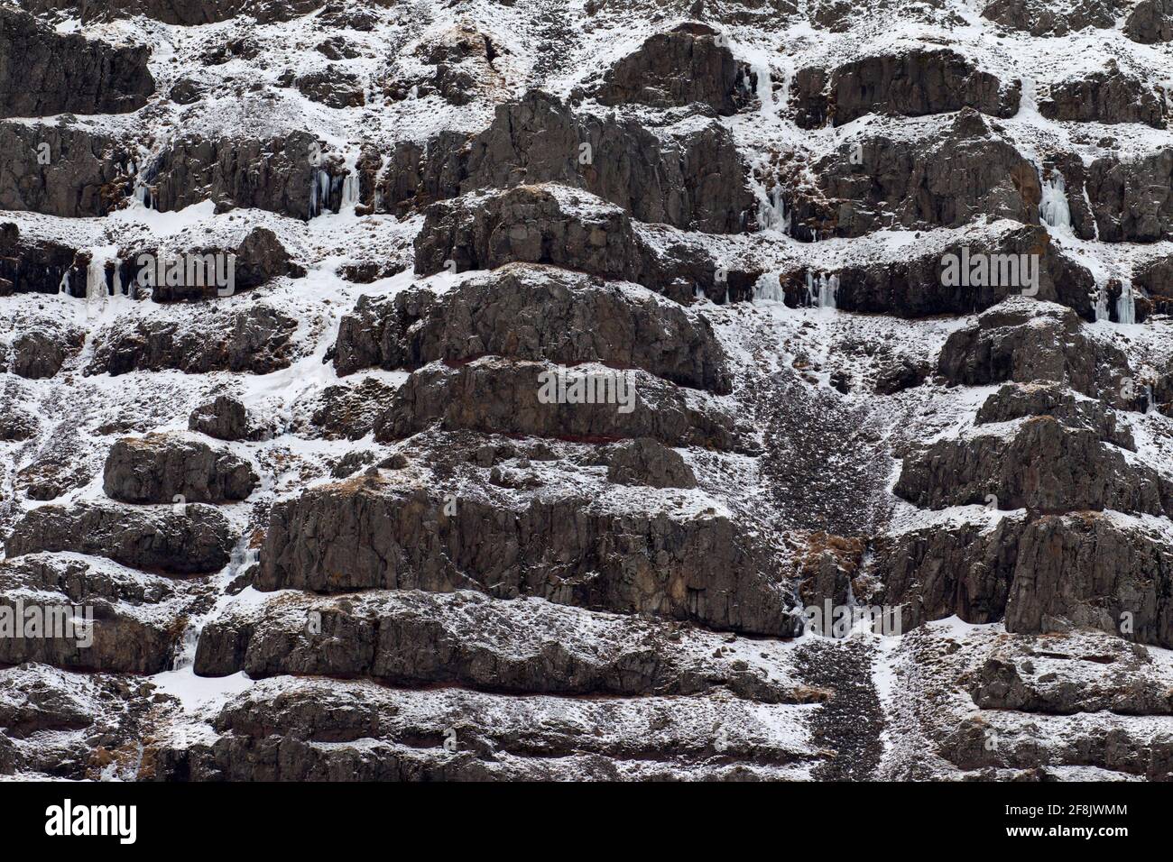 Fels- und Schneemuster am Berghang im Winter bei Snaefellsnes, Westisland Stockfoto