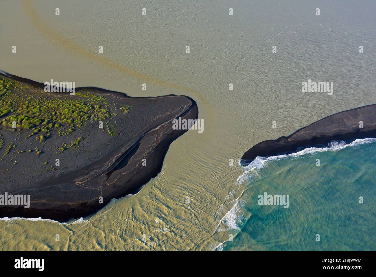 Luftaufnahme über Landeyjarsandur mit Strand mit schwarzem vulkanischem Sand und braunem Wasser, das im Sommer in Island mit Sediment im Meer übersät ist Stockfoto