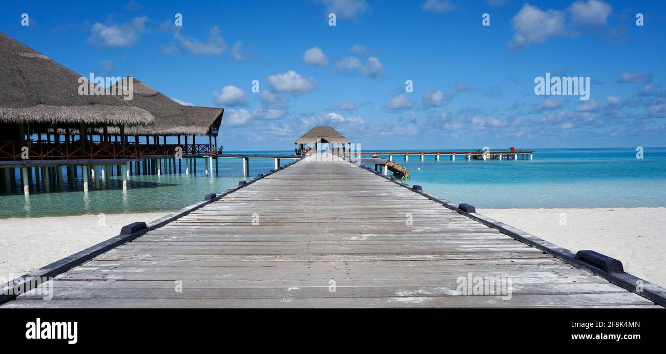 Hölzerner Pier führt Wasserbar auf dem indischen Ozean auf den Malediven. Türkisfarbene Lagune Stockfoto