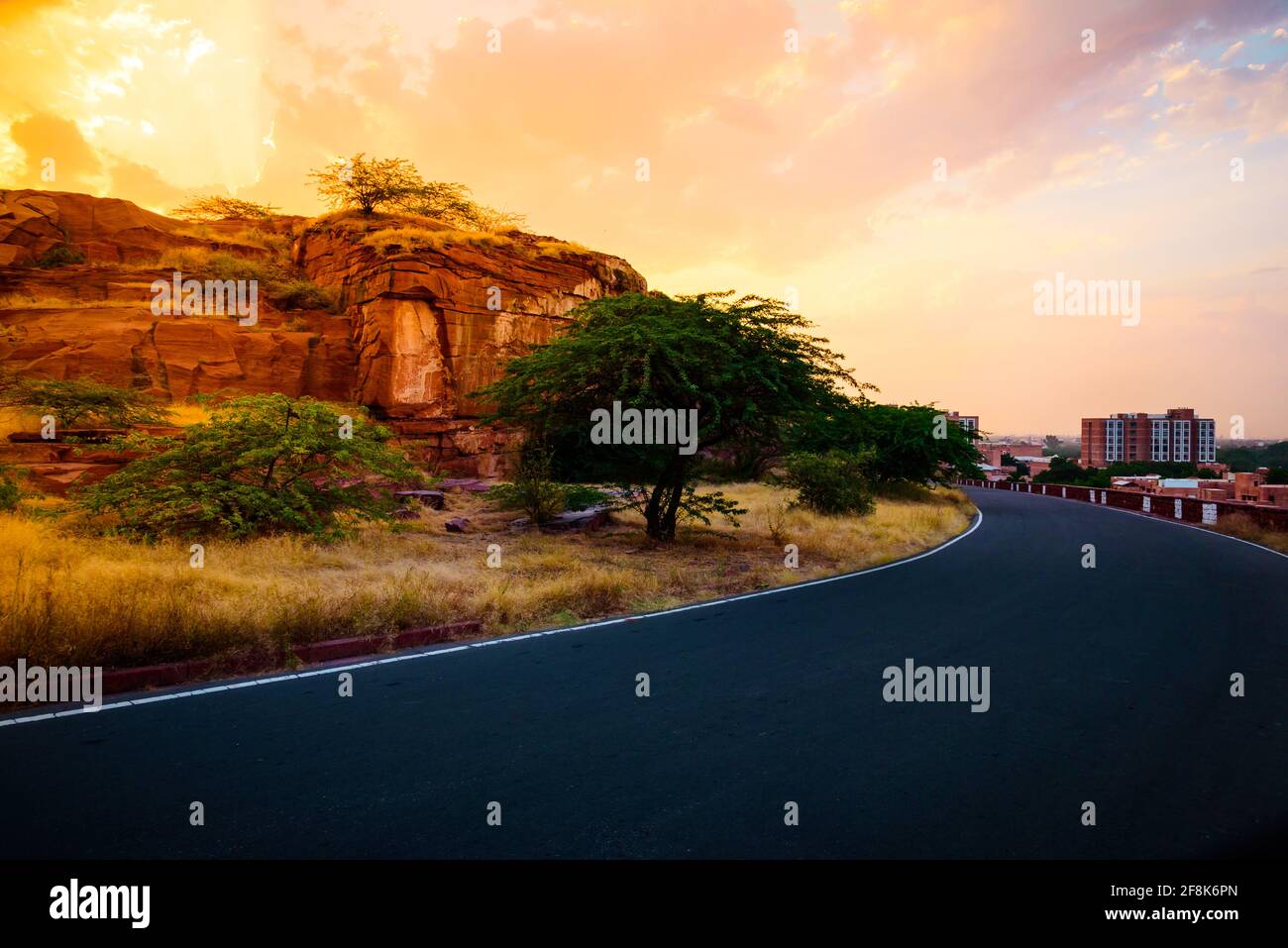 Blick auf den Weg zum Umaid Bhawan Palace durch präkambrianische Ära rot Sandsteingebirge, die in Jodhpur Group-Malani Igneous Suite Contact fällt Geologisch Stockfoto