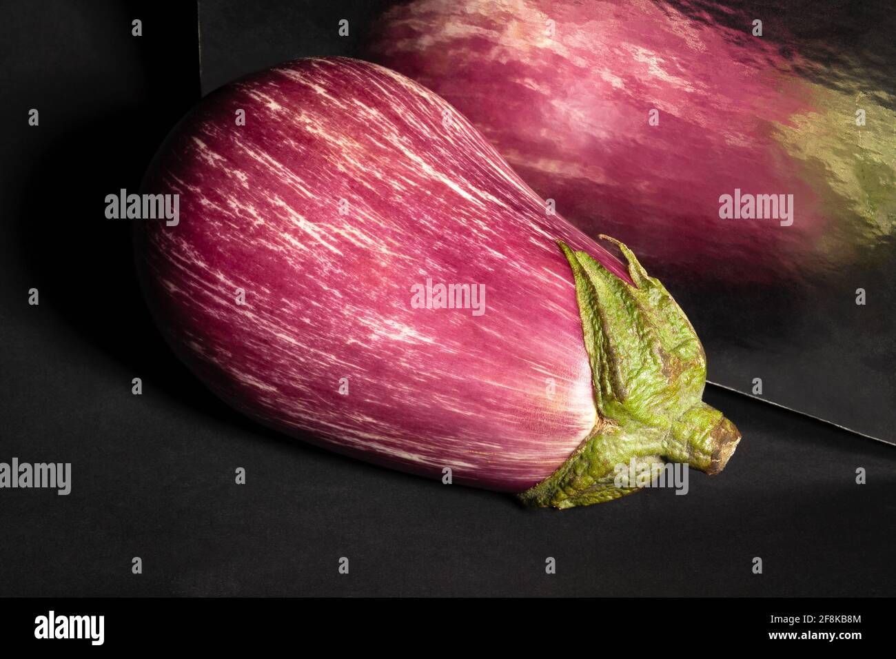 Gestreifte Aubergine auf schwarzem Hintergrund Stockfoto