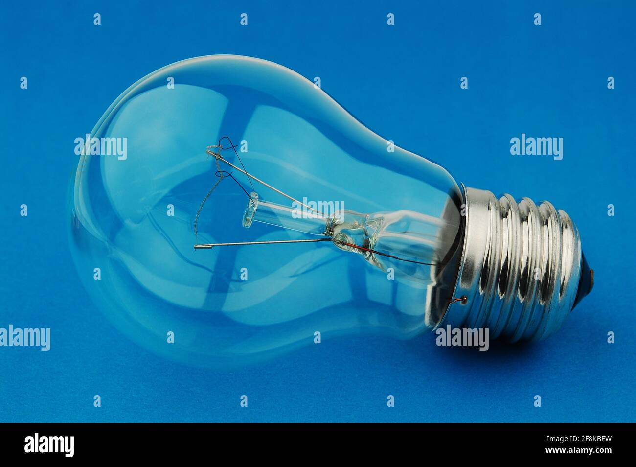 Elektrische Glühbirne auf blauem Hintergrund. Ausschalten. Konzept der drahtlosen Kraftübertragung. Kreative Krise Müdigkeit mentalen Stress. Stockfoto