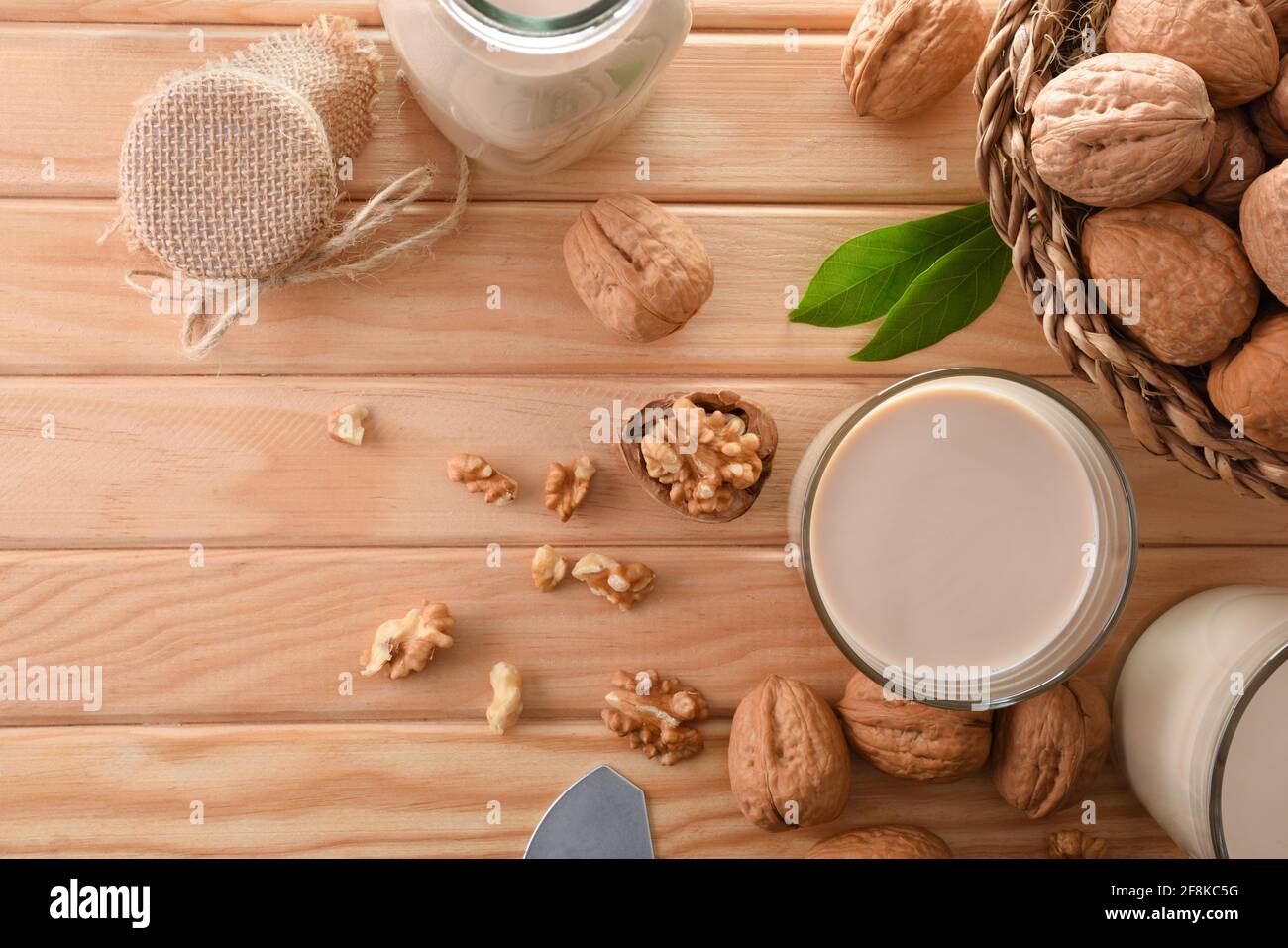 Glas alternativen Gemüsegetränks von Walnüssen mit Früchten auf Holztisch. Draufsicht. Stockfoto