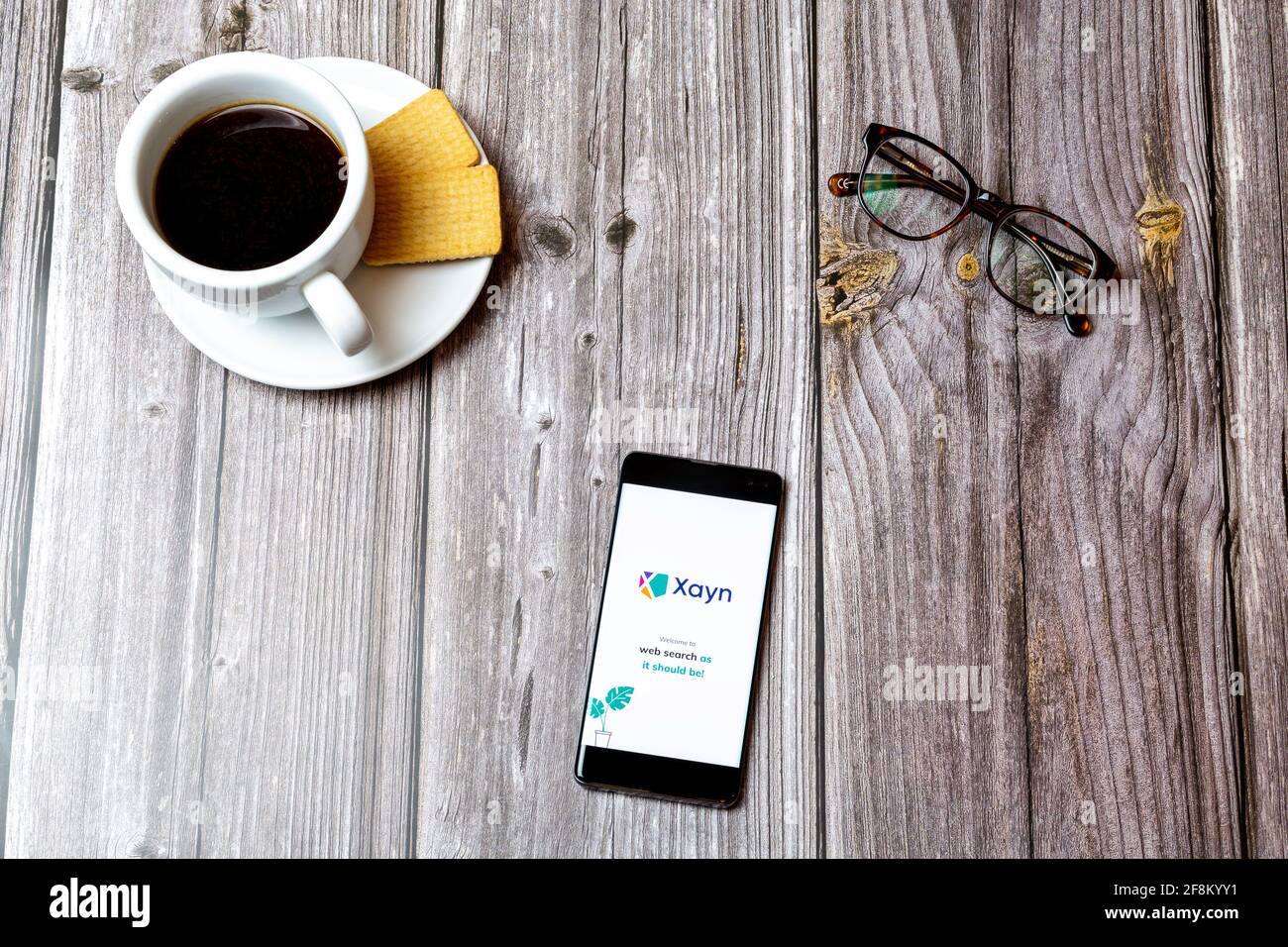 Ein Mobiltelefon oder Mobiltelefon, das auf einem Holzboden liegt Tabelle mit der Xayn-Websuchanwendung auf dem Bildschirm Stockfoto