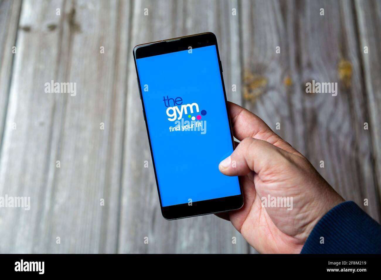 Ein Mobiltelefon oder Mobiltelefon, das in einem gehalten wird Hand zeigt die Gym Group App auf dem Bildschirm Stockfoto