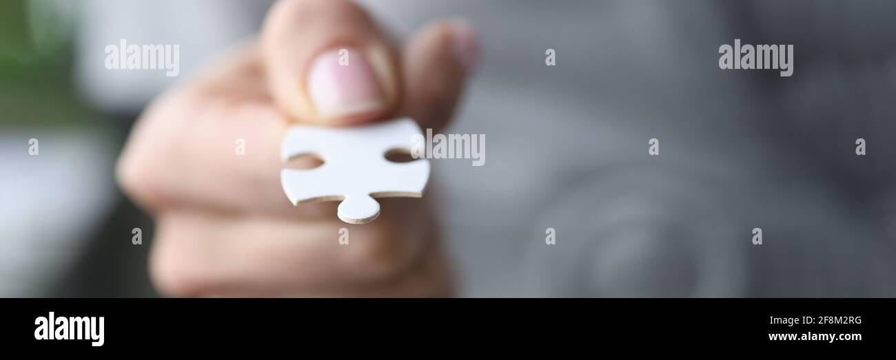 Männliche Finger halten ein weißes Puzzle. Stockfoto