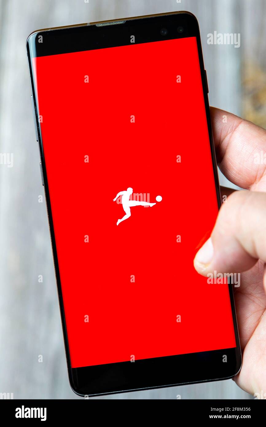Ein Mobiltelefon oder Mobiltelefon, das in einem gehalten wird Hand zeigt die bundesliga-App auf dem Bildschirm Stockfoto