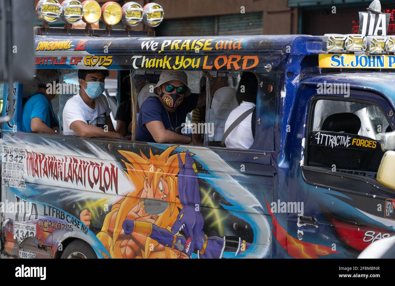 Passagiere in einem bunten Multicab öffentlichen Versorgungsfahrzeug mit Gesichtsmasken, Cebu City, Philippinen Stockfoto