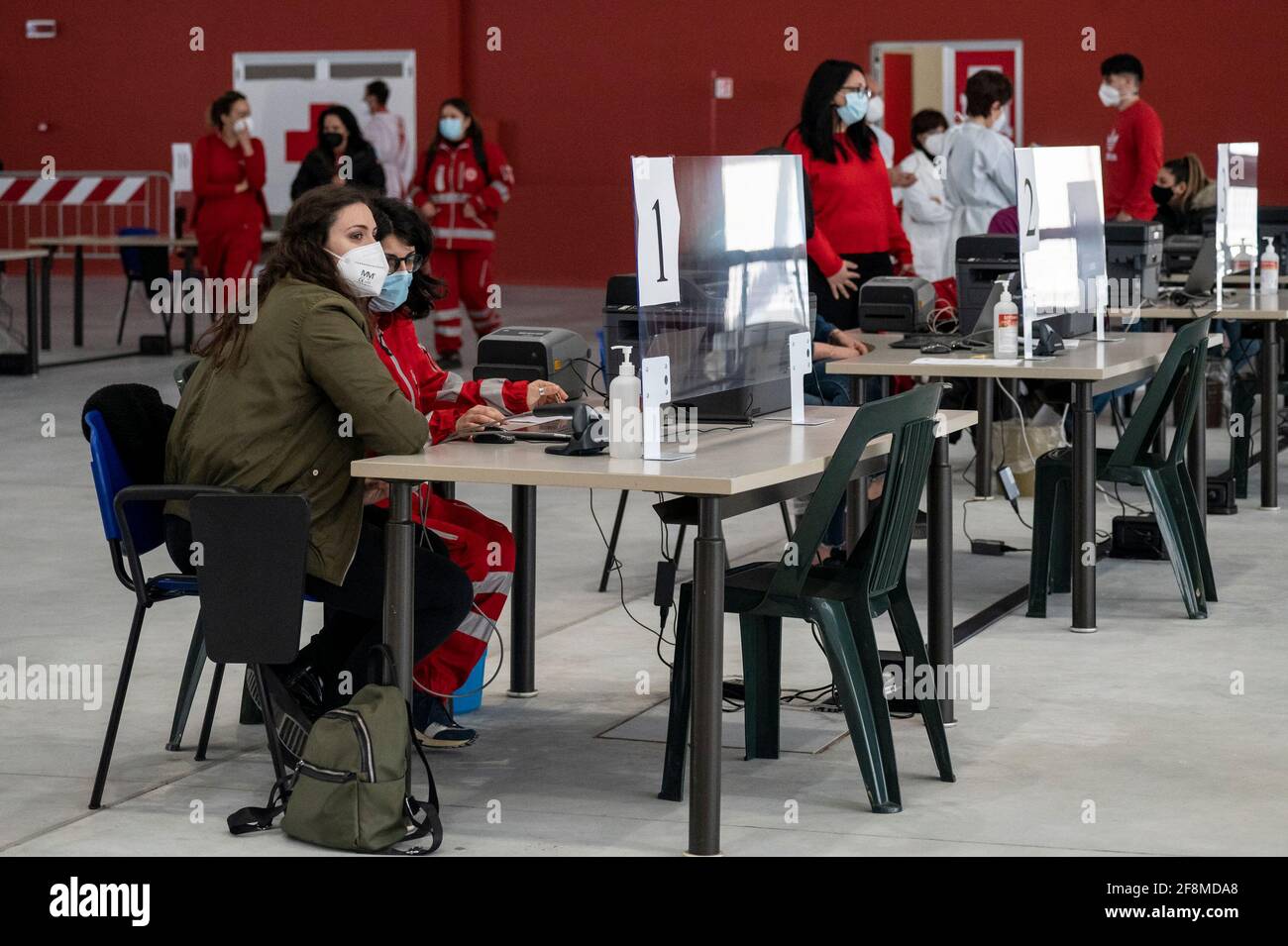 Junge Freiwillige des Roten Kreuzes auf den Arbeitsstationen gesehen. Am neuen Impfzentrum Covid-19 im Messezentrum (Ente Fiera) in Catanzaro Lido hatten sich fast 500 Menschen im Alter von 70 Jahren und älter, ohne besondere Krankheiten, ihren Platz für die Verabreichung des Impfstoffs AstraZeneca reserviert. Die Mitglieder des italienischen Roten Kreuzes und des Katastrophenschutzes helfen den örtlichen Sanitäterinnen und Sanitäranlagen bei der Umsetzung des Impfprogramms. Stockfoto