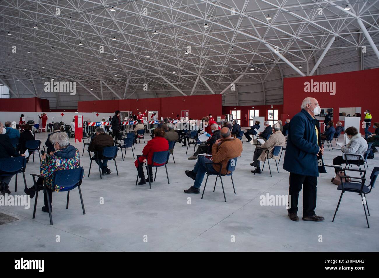 Catanzaro, Italien. April 2021. Menschen gesehen, während sie in der Wartezeit für ihre Reihe sitzen. Am neuen Impfzentrum Covid-19 im Messezentrum (Ente Fiera) in Catanzaro Lido hatten sich fast 500 Menschen im Alter von 70 Jahren und älter, ohne besondere Krankheiten, ihren Platz für die Verabreichung des Impfstoffs AstraZeneca reserviert. Die Mitglieder des italienischen Roten Kreuzes und des Katastrophenschutzes helfen den örtlichen Sanitäterinnen und Sanitäranlagen bei der Umsetzung des Impfprogramms. (Foto von Valeria Ferraro /SOPA Images/Sipa USA) Quelle: SIPA USA/Alamy Live News Stockfoto