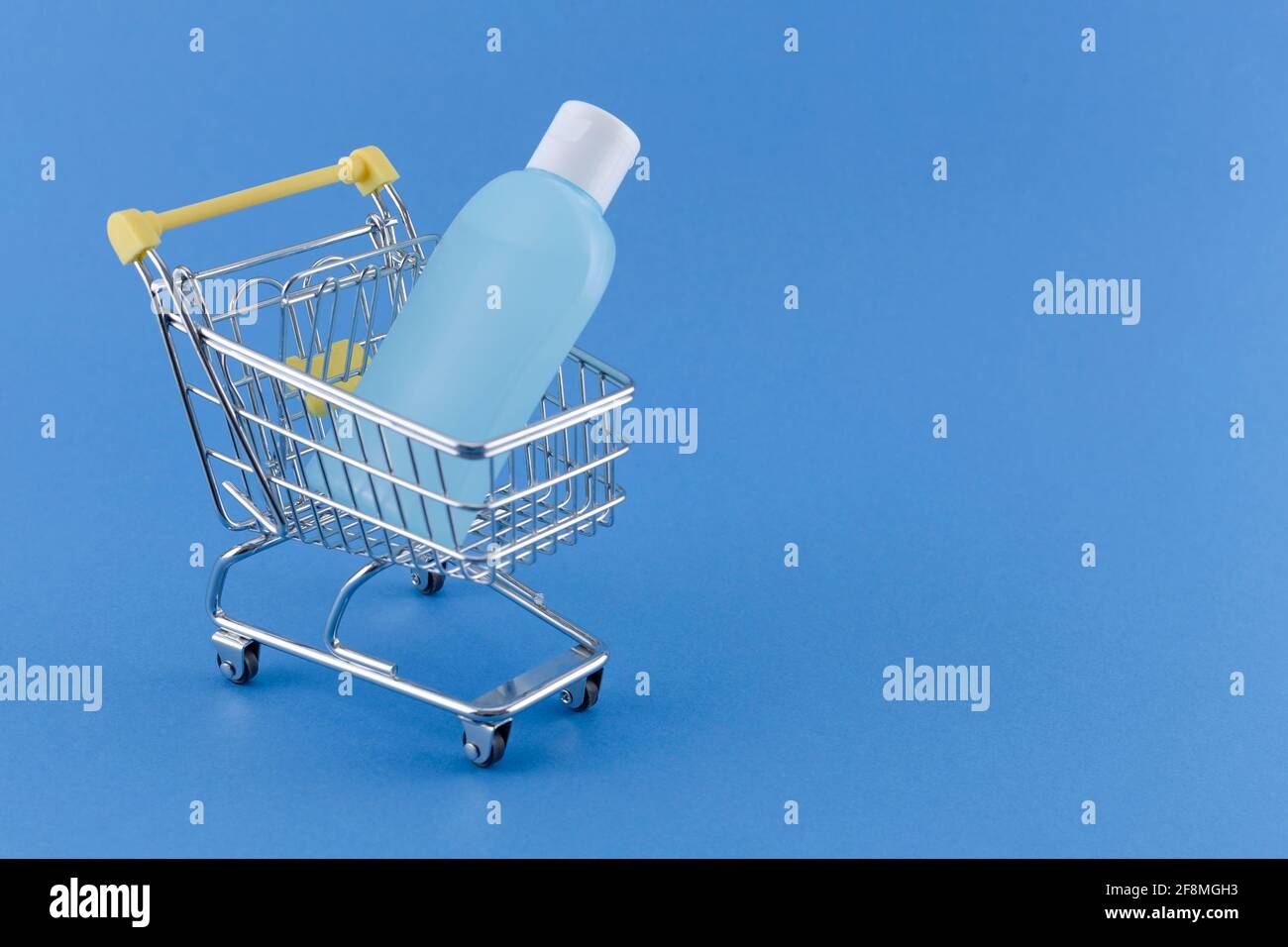 Warenkorb mit Desinfektionsmittel gefüllt Alcholol Flasche Kopierer Platz auf blau bg für Coronavirus vorbeugende Maßnahme, Schutz während Grippe vir Stockfoto