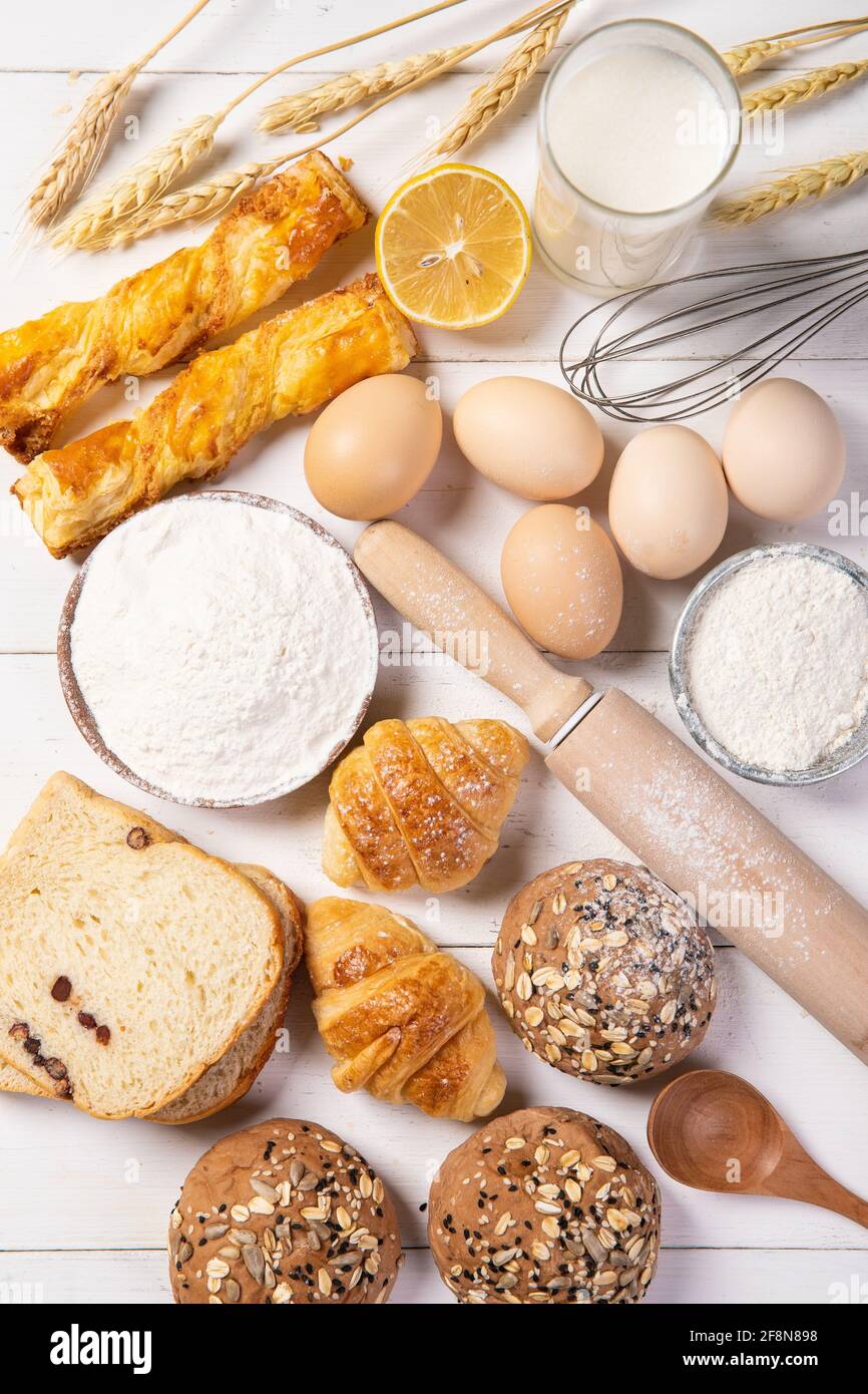 Vertikale Aufnahme von Zutaten in die Herstellung von Brot und frisch gebacken Brot auf dem Tisch Stockfoto
