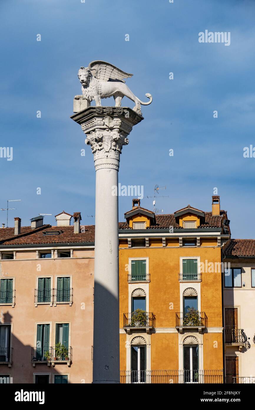 Statue eines geflügelten Löwen auf der Spitze eines Spalte im Hintergrund von Gebäuden und blauer Himmel in Italien Stockfoto