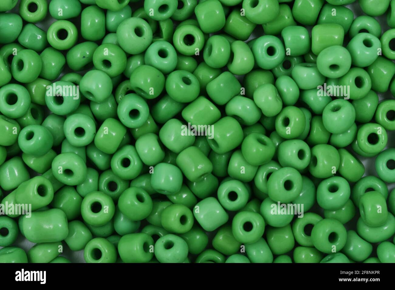 Grüne Perlen auf dem weißen Hintergrund Hintergrund Nahaufnahme, Makro, machen Perlen Halskette Stockfoto