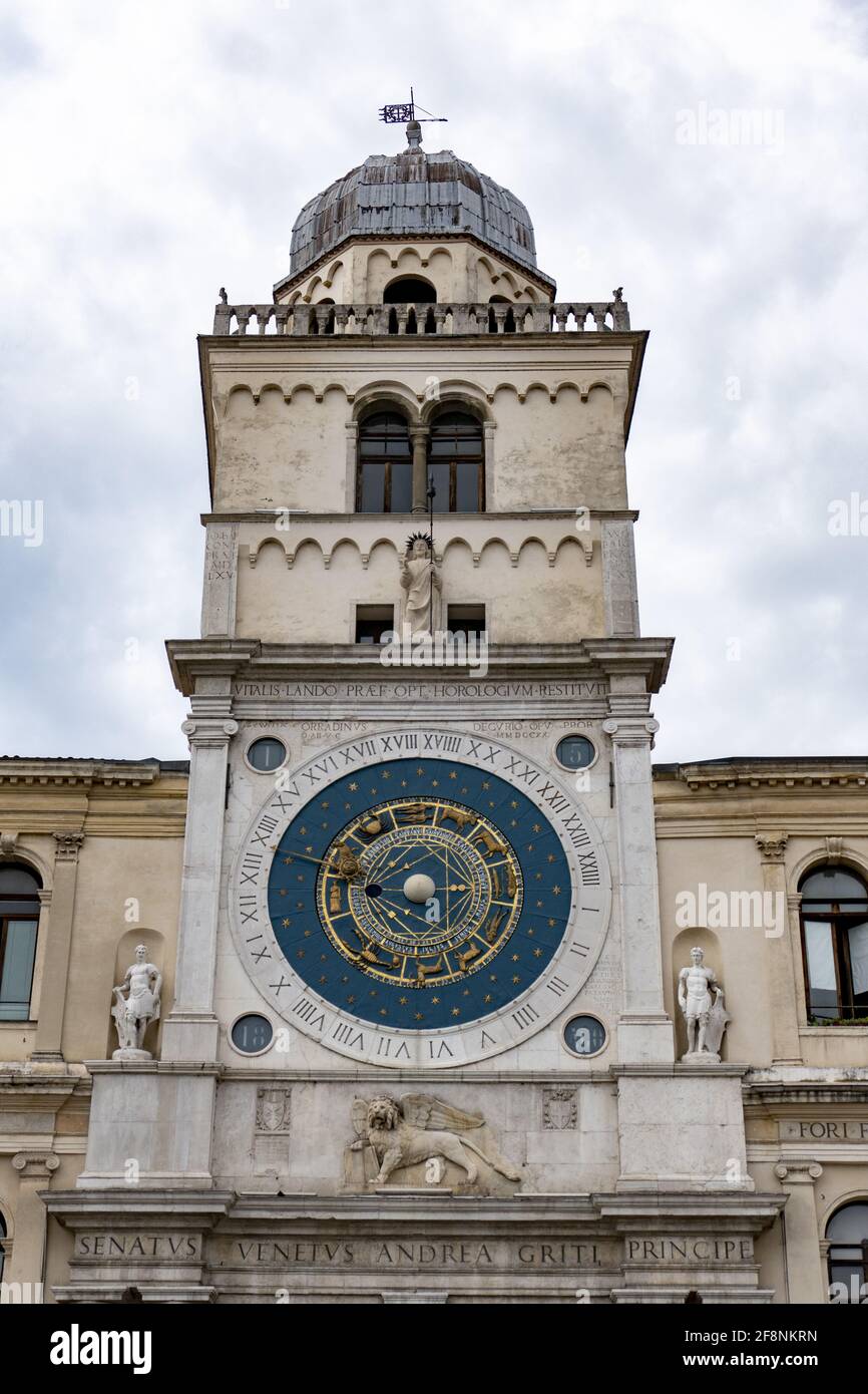 Vertikale Aufnahme eines Uhrturms mit Skulpturen unter einem wolkiger Himmel auf der Piazza dei Signori Padua Italien Stockfoto