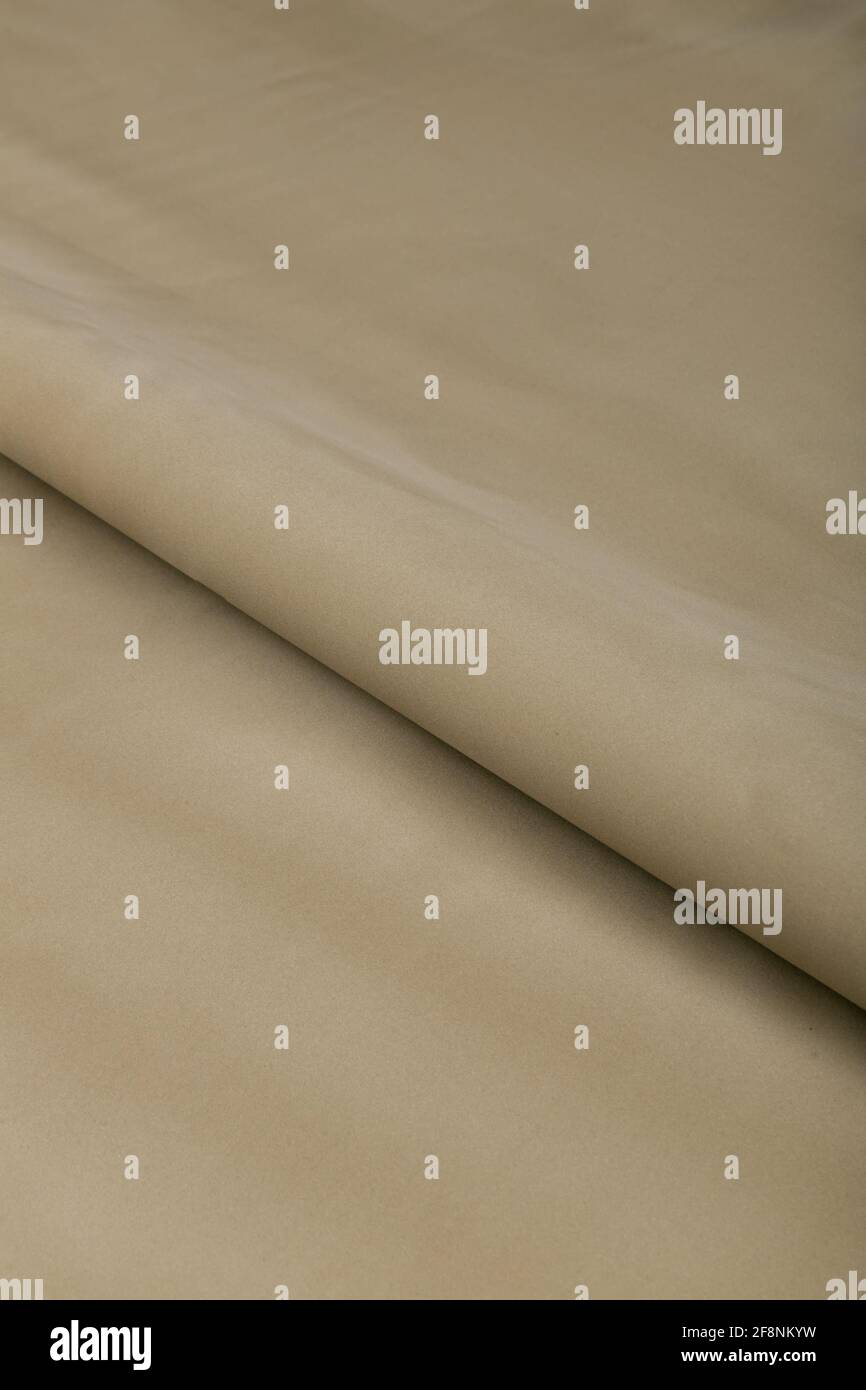 Farbiger brauner Textil-Satinstoff in Falten und Wellen gefaltet Mit Highlights und Textur schimmert im Licht Stockfoto