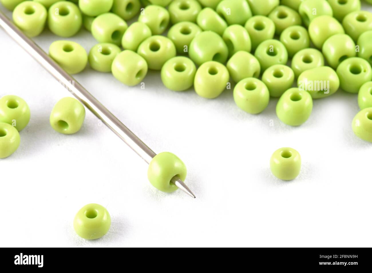 Perlen auf weißem Hintergrund mit Nadel Perlen mit Nadel Close up, Makro, machen Perlen Halskette, Perlen Häkeln Daily Perlenstickerei Stockfoto