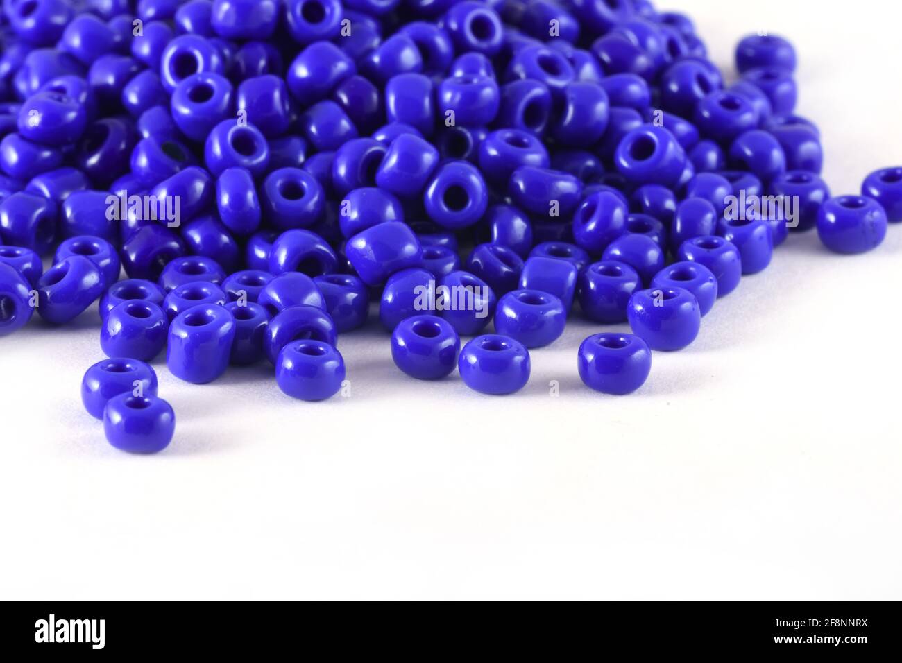 Nahaufnahme der blauen Perlen auf dem weißen Hintergrund Hintergrund Makro, machen Perlen Halskette Stockfoto