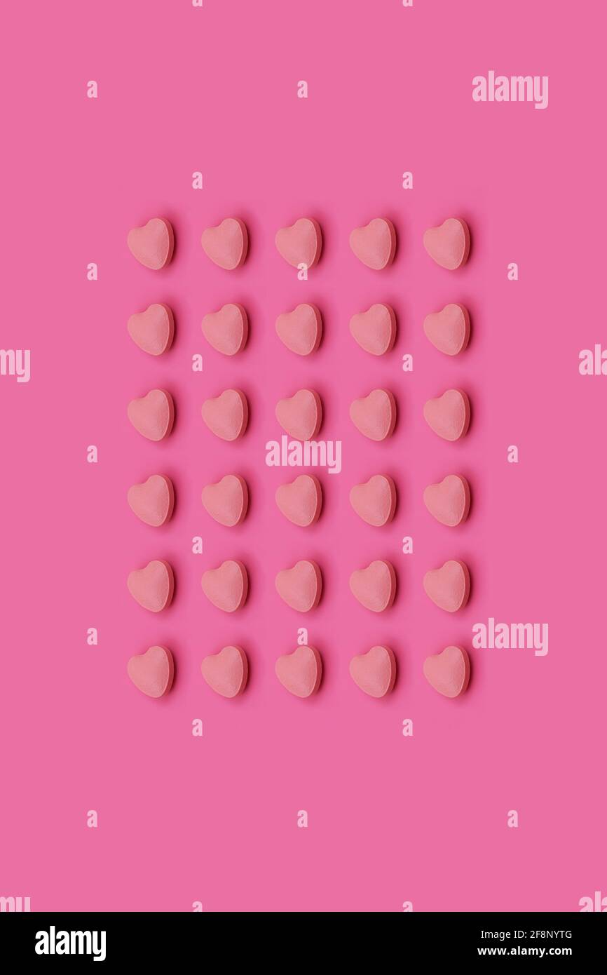 Herzform Pharmazeutische Medizin Tablette auf einem rosa Hintergrund, Medizin kreative Konzepte Minimal Stil mit bunten Papier Hintergrund Stockfoto