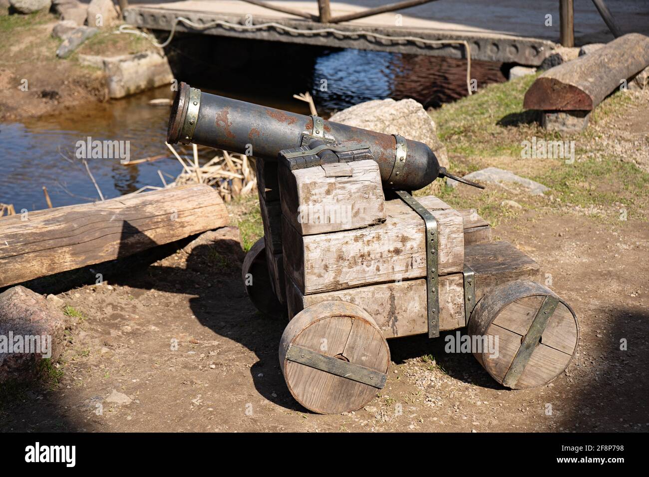 In der Nähe des Teiches steht eine alte Kanone auf Holzrädern Stockfoto