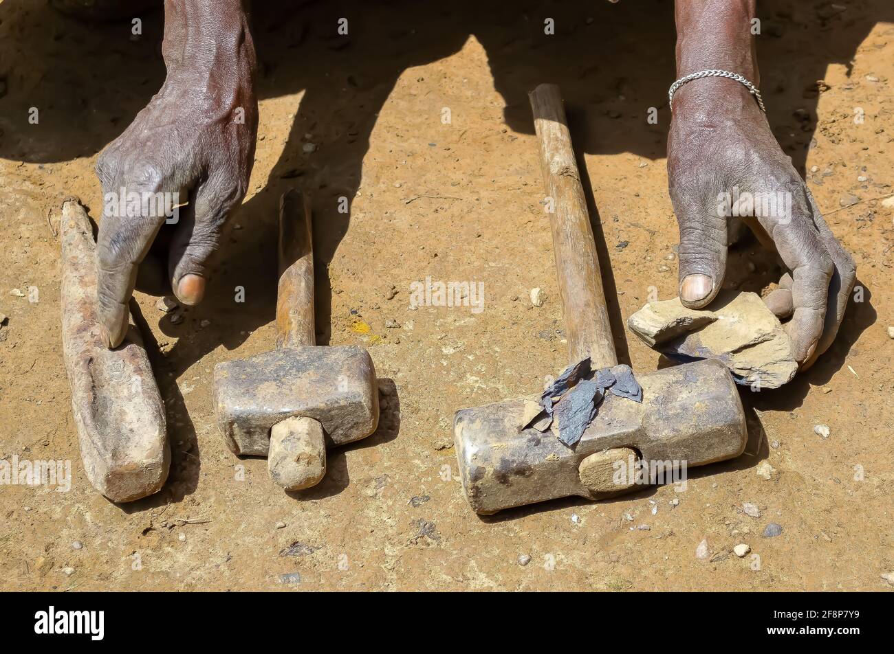 Rückspulzeit in Uganda: Der Schaffellbälge lässt Luft in einen kohlebefeuerten Ofen, der Schmied hackt rotes heißes Metall aus und hämmert es in Werkzeuge Stockfoto