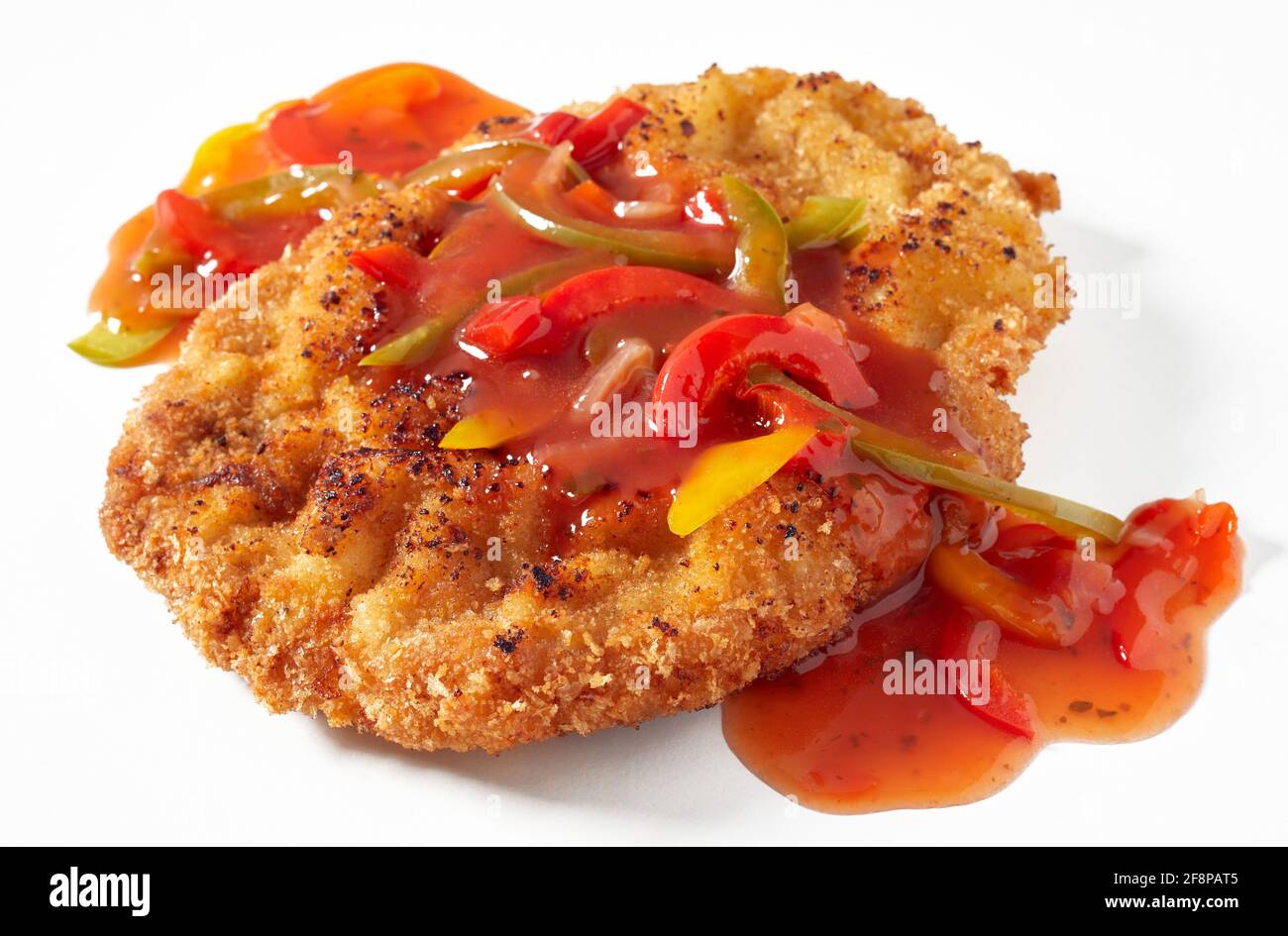 Nahaufnahme von appetitlich gebratenem paniertem Fleisch Schnitzel mit aromatischem serviert zigeunersauce mit Tomatenmark und bunten Paprika mit gemacht Paprika auf Weiß Stockfoto