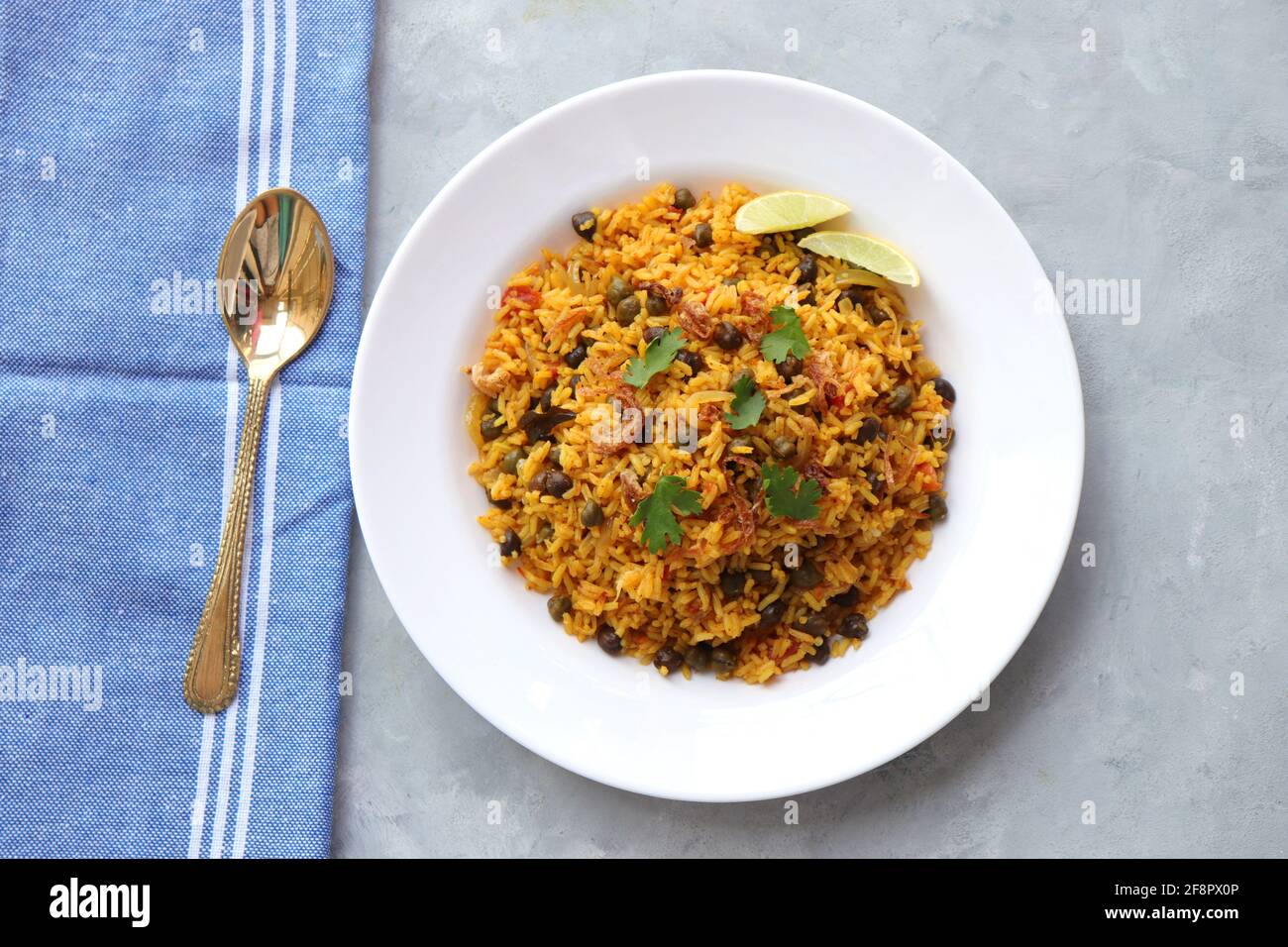 Indische Küche - Kichererbsen Biryani, chole Pulao. Garniert mit gebratener Zwiebel, gehacktem Koriander und Zitronenkeilen. Kala chana biryani. Raum kopieren Stockfoto