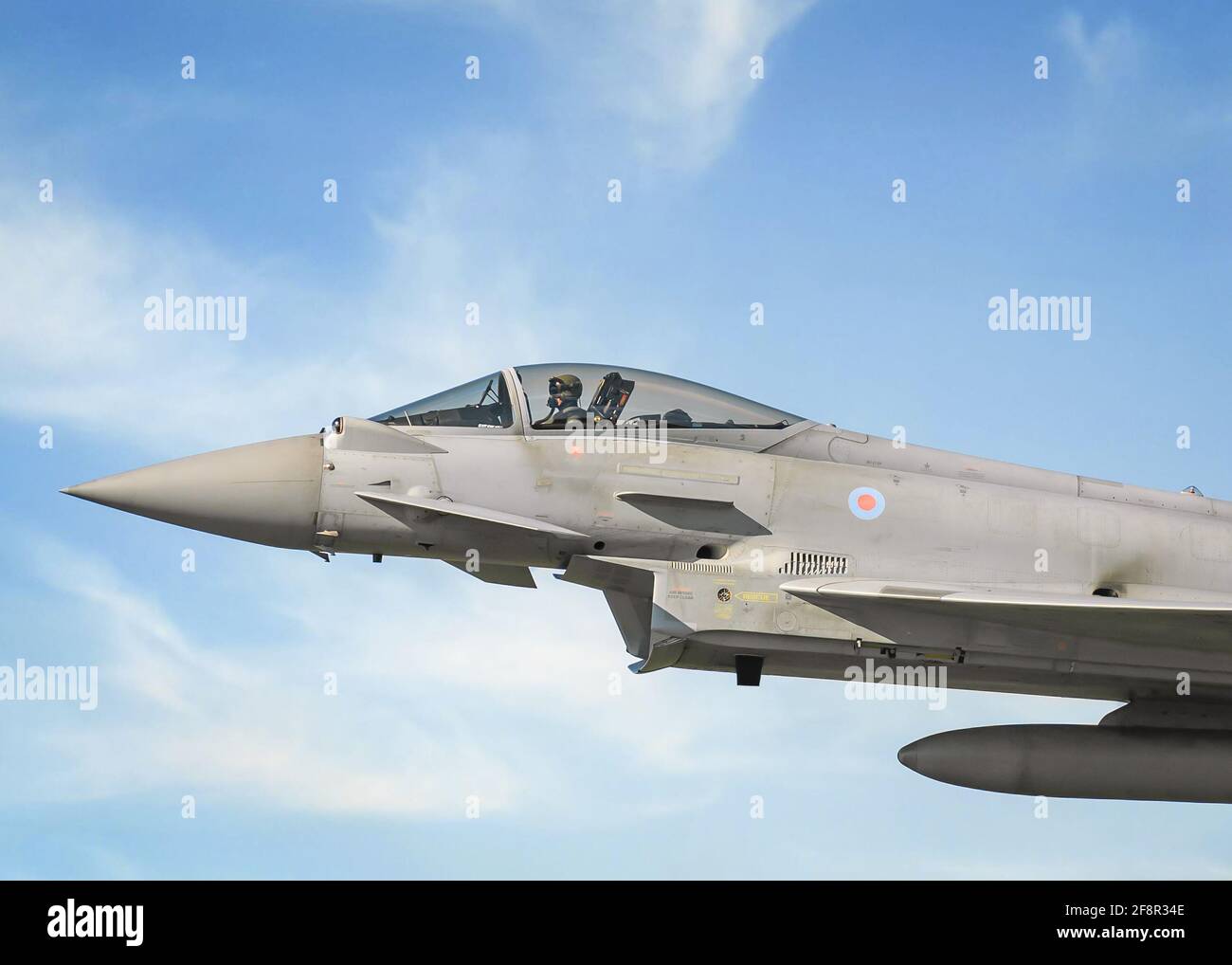 RAF Coningsby Lincolnshire Typhoon EF 2000 Eurofighter-Düsenflugzeug im Flug. Nahaufnahme des Cockpits und eines einzelnen Piloten aus dem Seitenprofil, der mit Geschwindigkeit fliegt Stockfoto