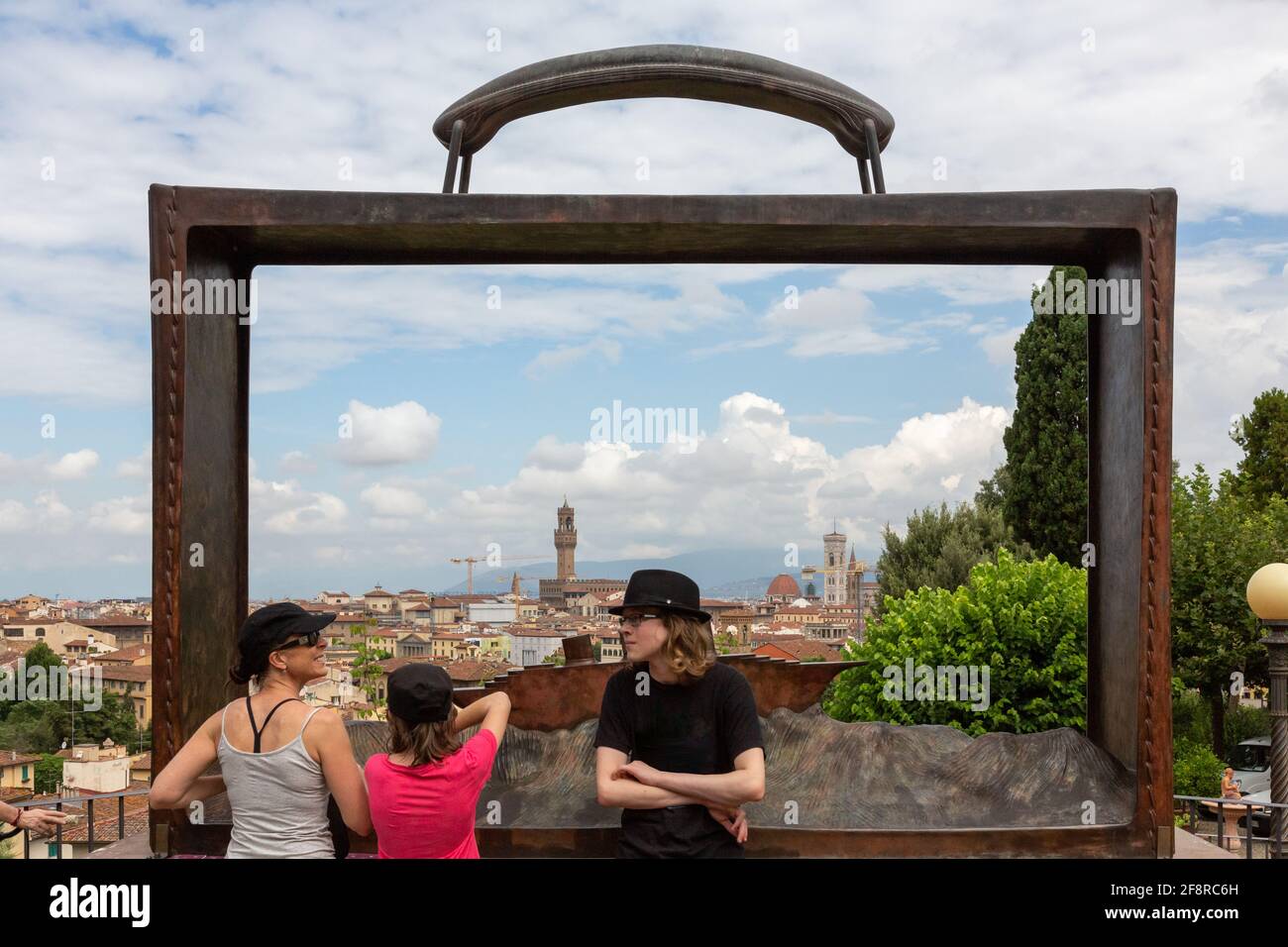 Tourist Family Pose vor Bronze Kunstwerk eines Koffers mit Blick auf Florenz, Italien Stockfoto