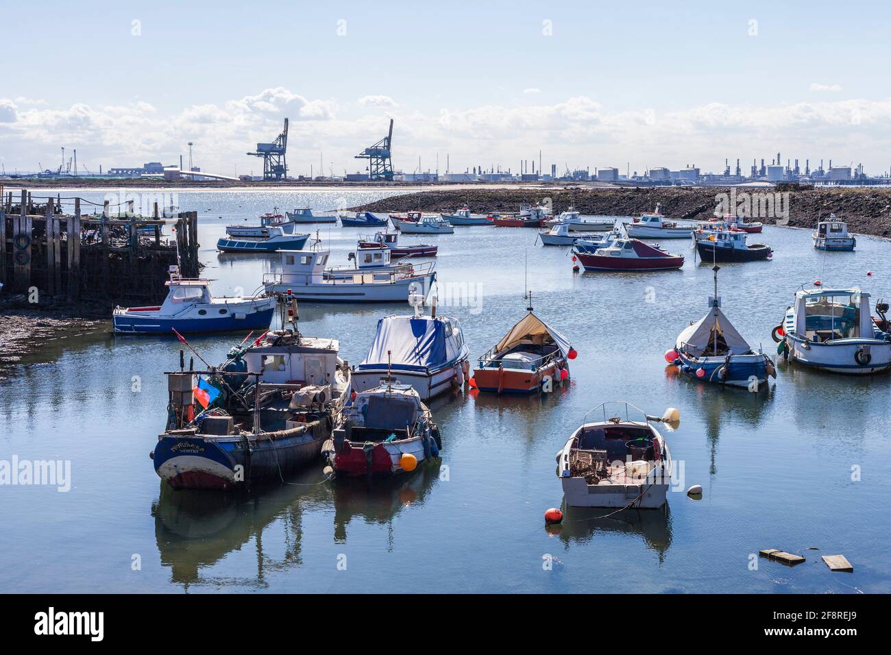 Ein Blick von Paddys Hole, Redcar, England, Großbritannien, zeigt die festgestemmten Boote und den industriellen Hintergrund von Teesport Stockfoto