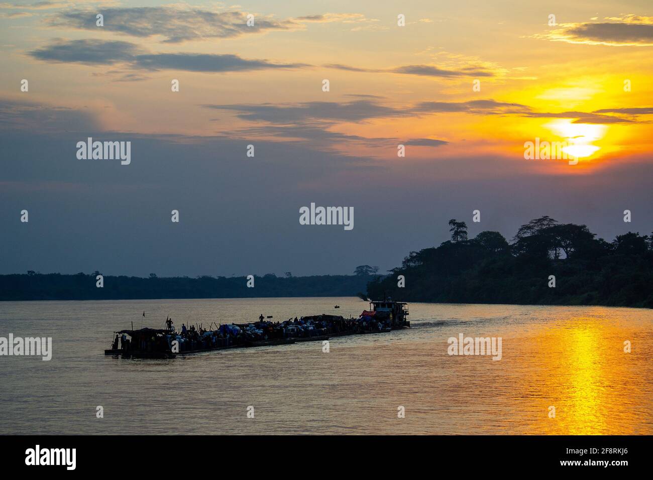 Barge, die bei Sonnenuntergang Kisangani ablegt und den Kongo entlang nach Kinshasa fährt. Demokratische Republik Kongo, Zentralafrika. Stockfoto