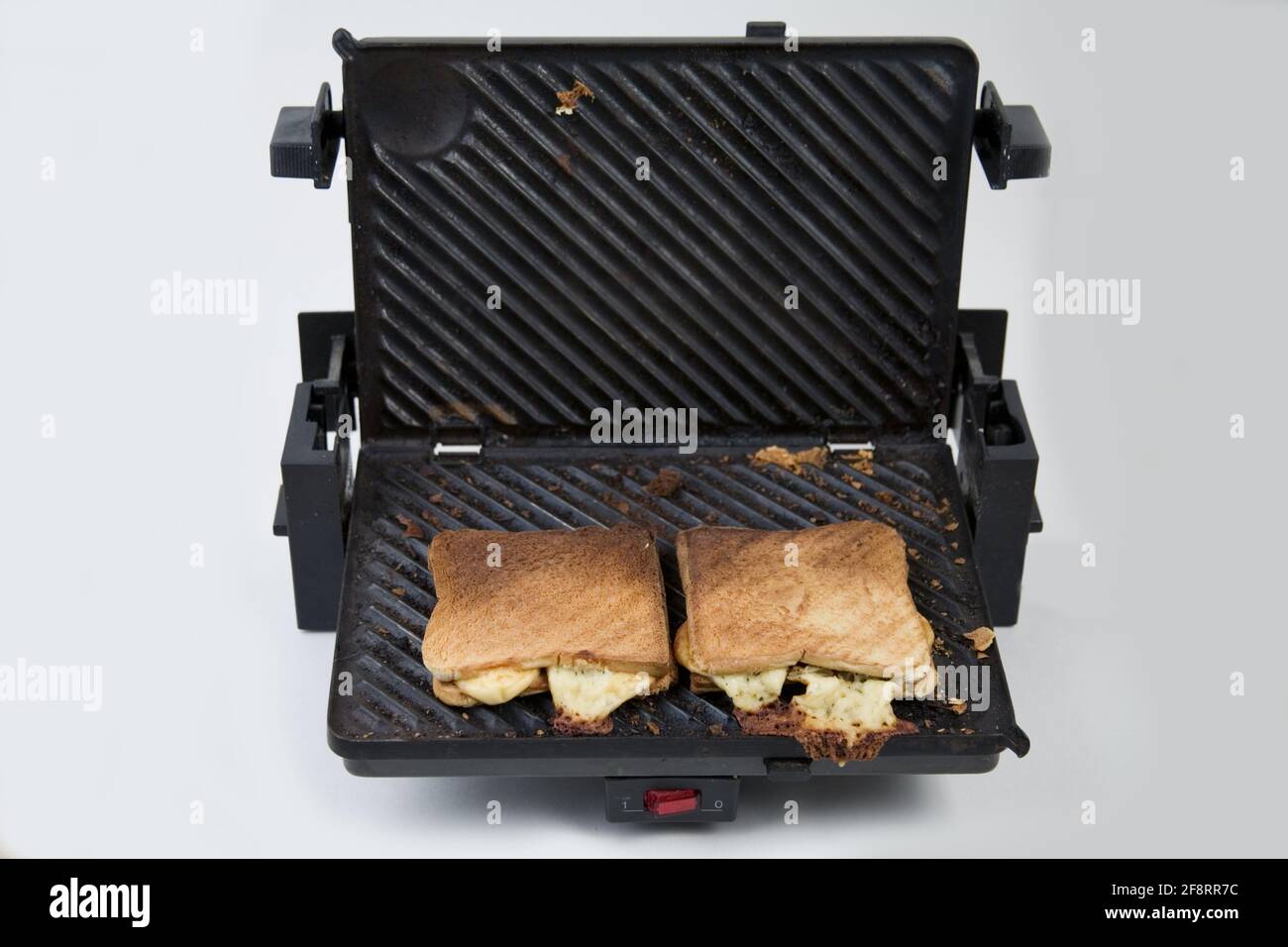 Gebrauchter Kontaktgrill mit Toaststücken und gebranntem Käse Stockfoto